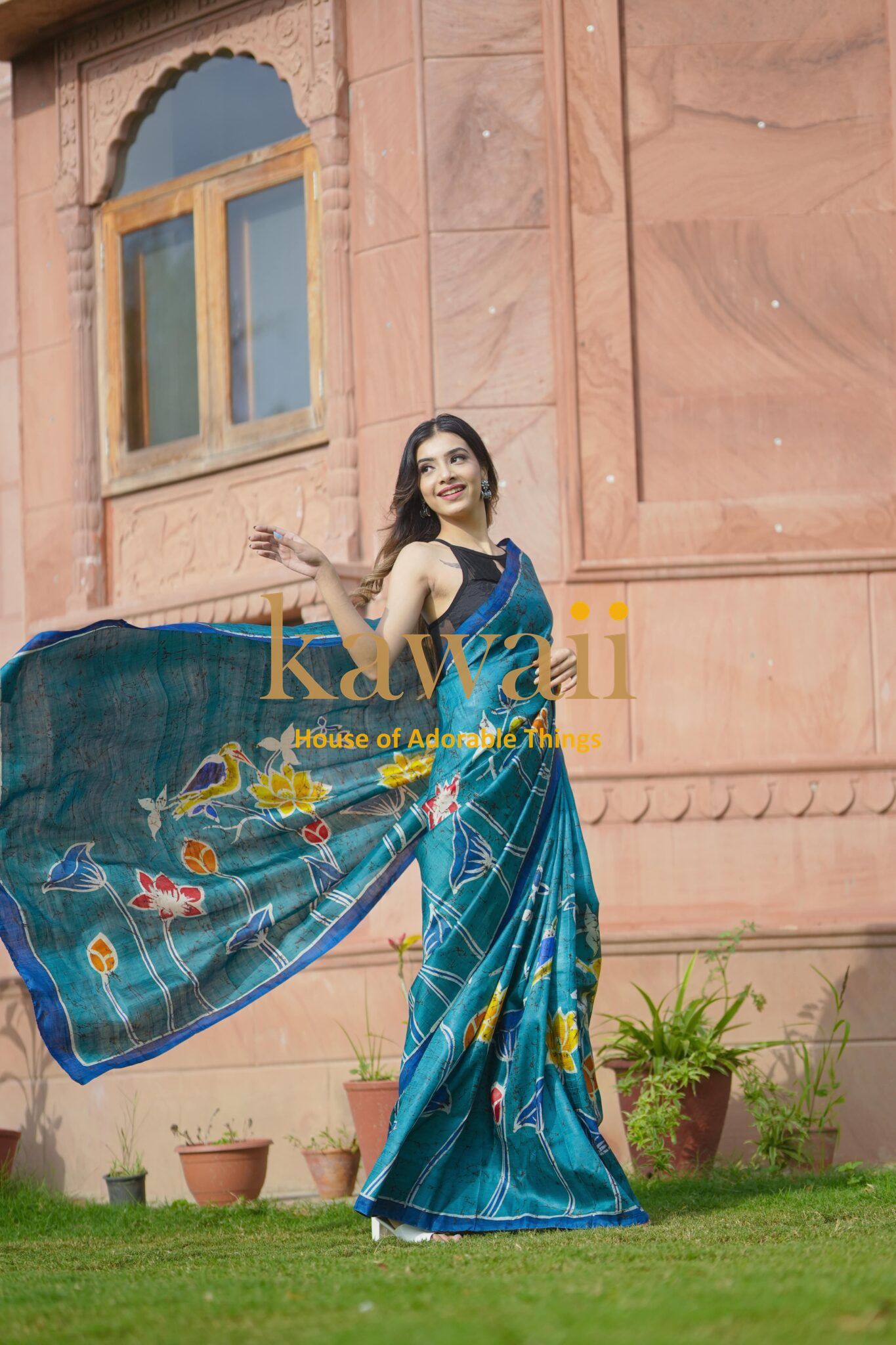 Kawaii blue floral batik saree worn by woman outdoors with graceful drape in sunlight