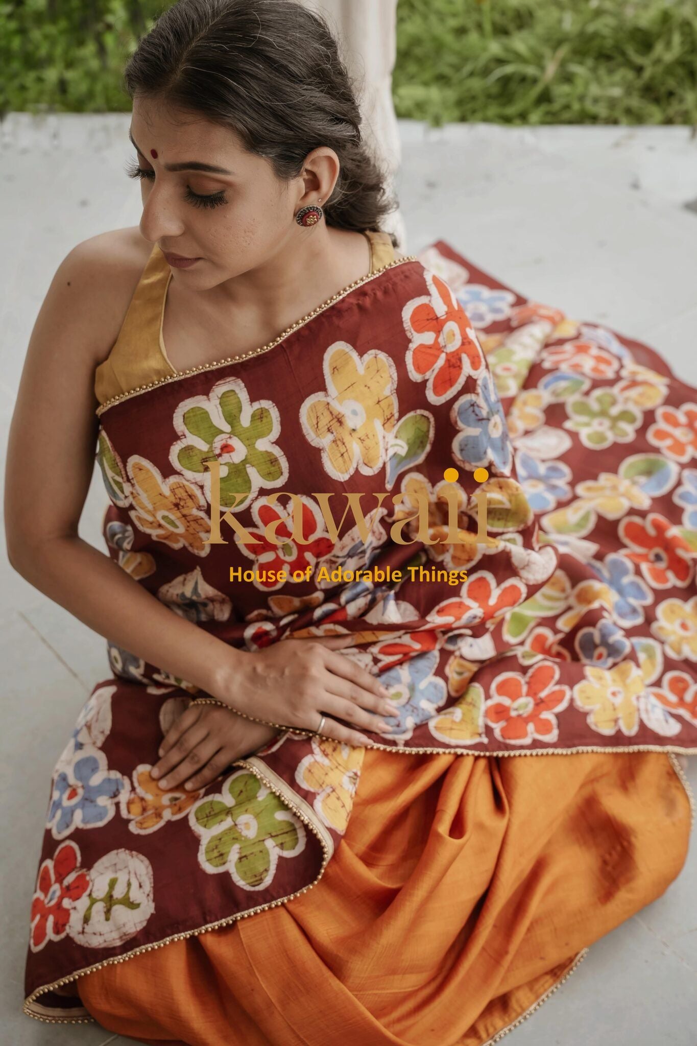 Kawaii batik saree with colorful floral patterns draped on woman wearing orange blouse