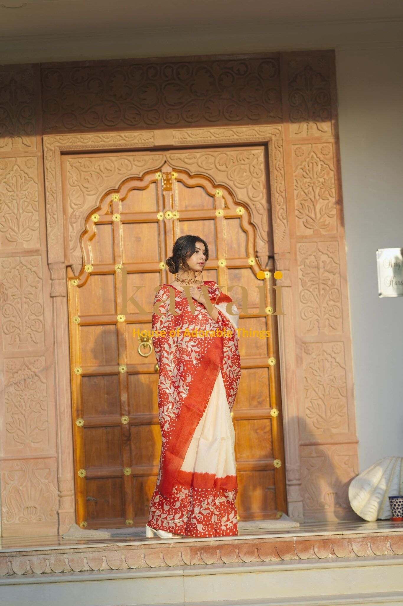 Kawaii batik saree featuring red and cream colors with intricate floral patterns worn by a woman