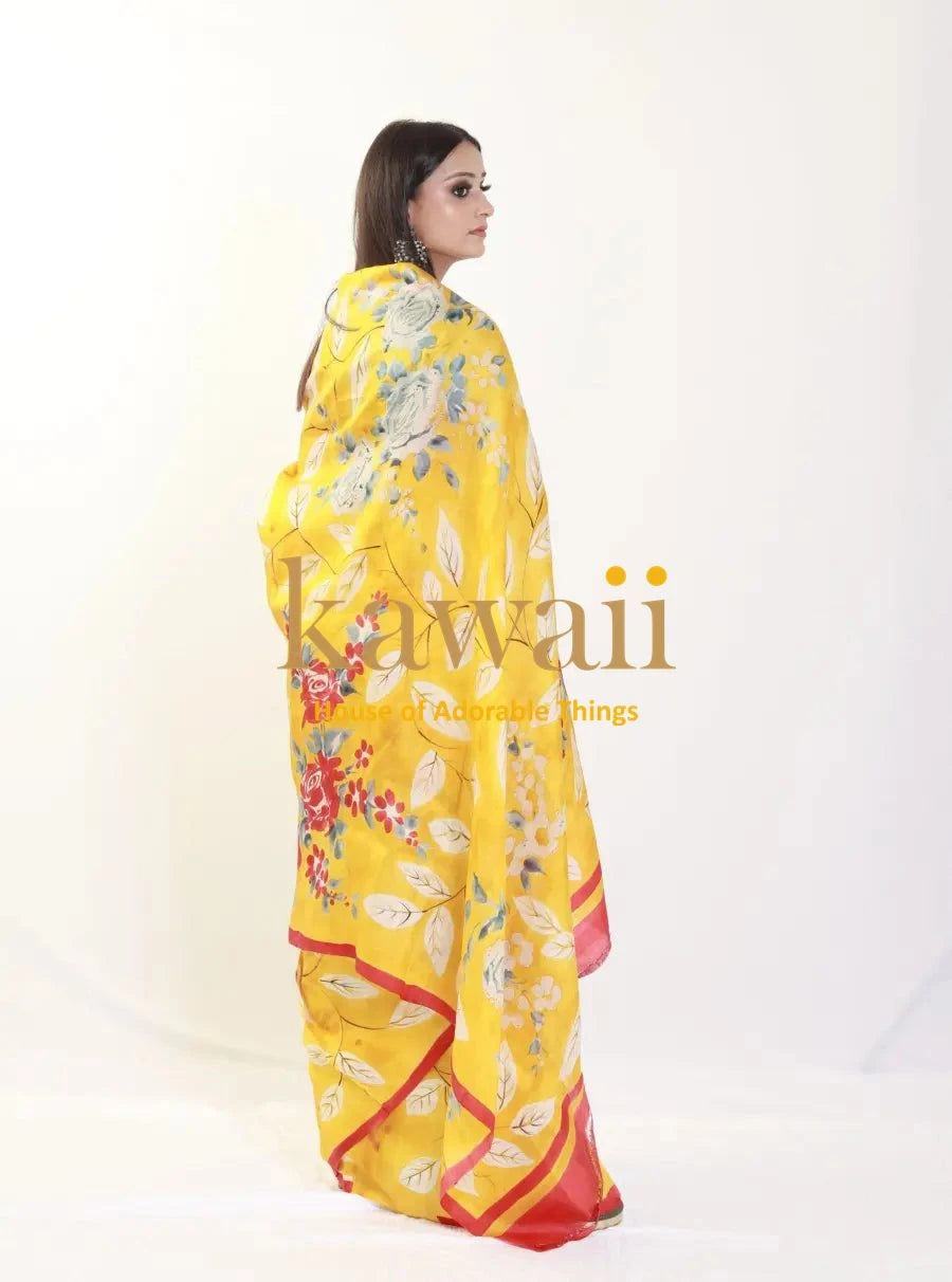 Kawaii yellow batik saree with floral patterns and red border worn by woman showing back view