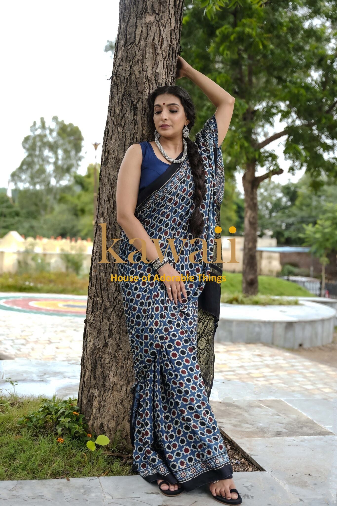Woman wearing best authentic handcrafted ajrakh saree online by Kawaii standing outdoors by a tree