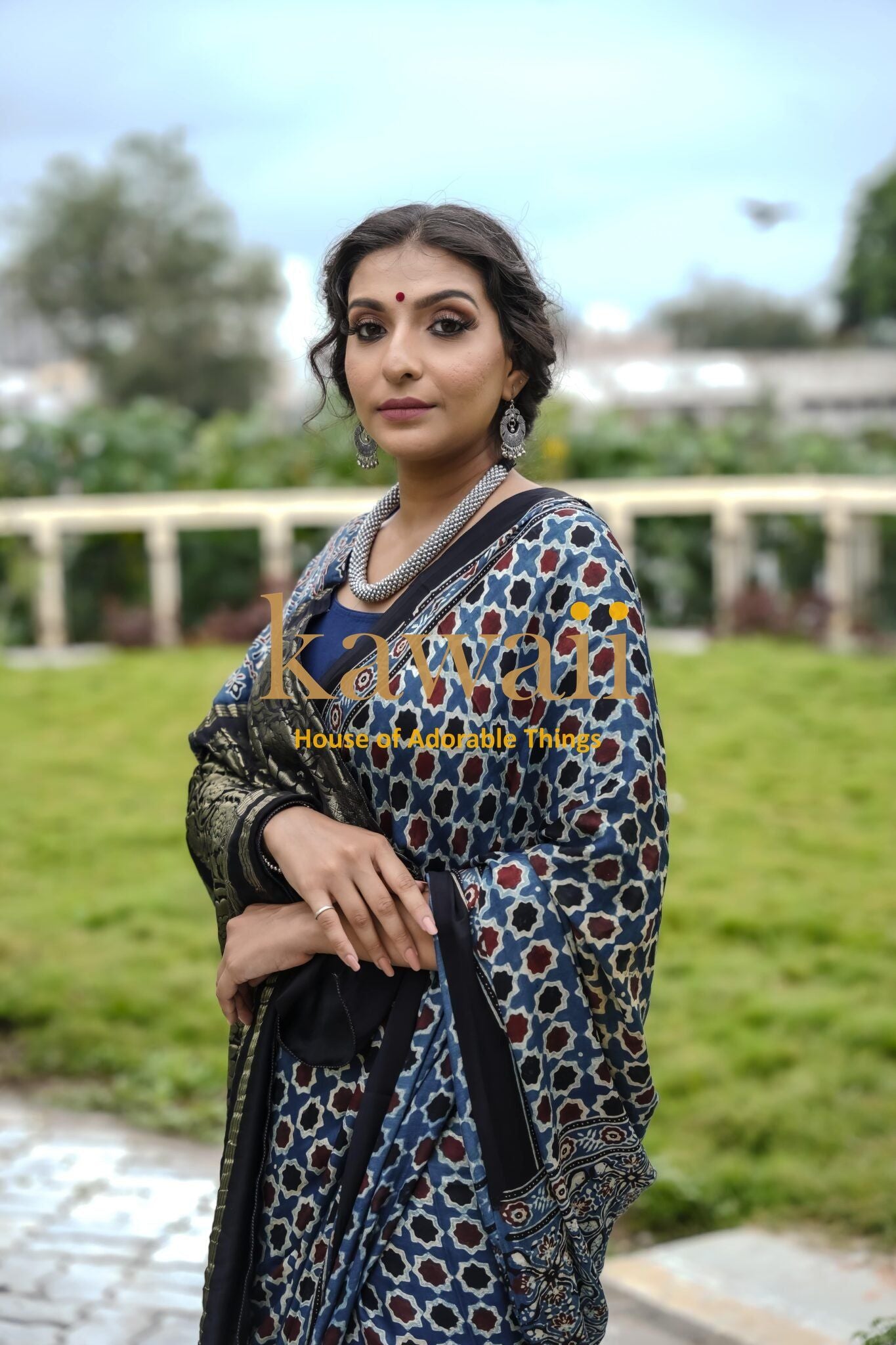 Kawaii best authentic handcrafted ajrakh saree online worn by woman in traditional jewelry outdoors