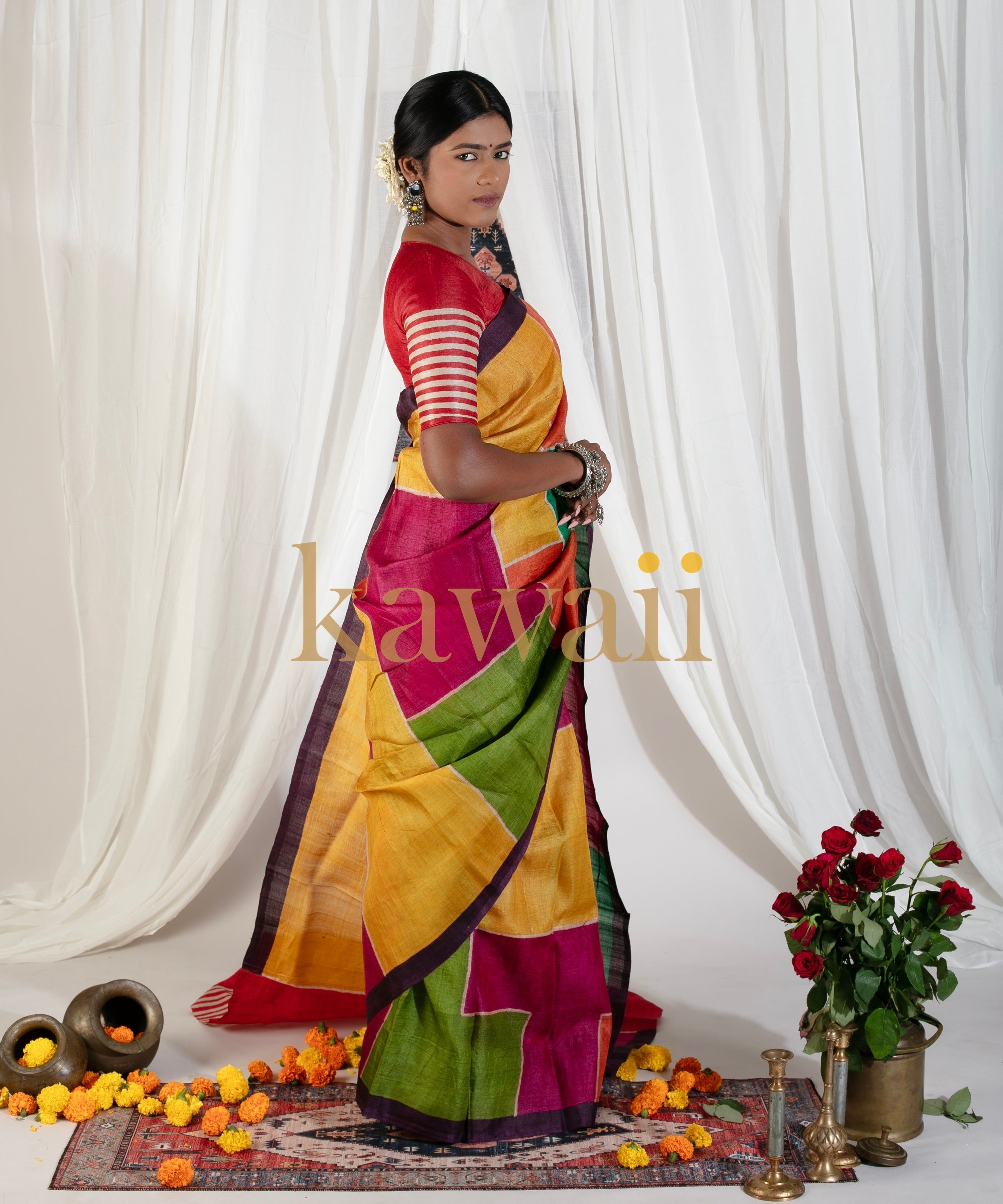 Woman wearing a colorful Kawaii block print saree with red blouse in a traditional setting