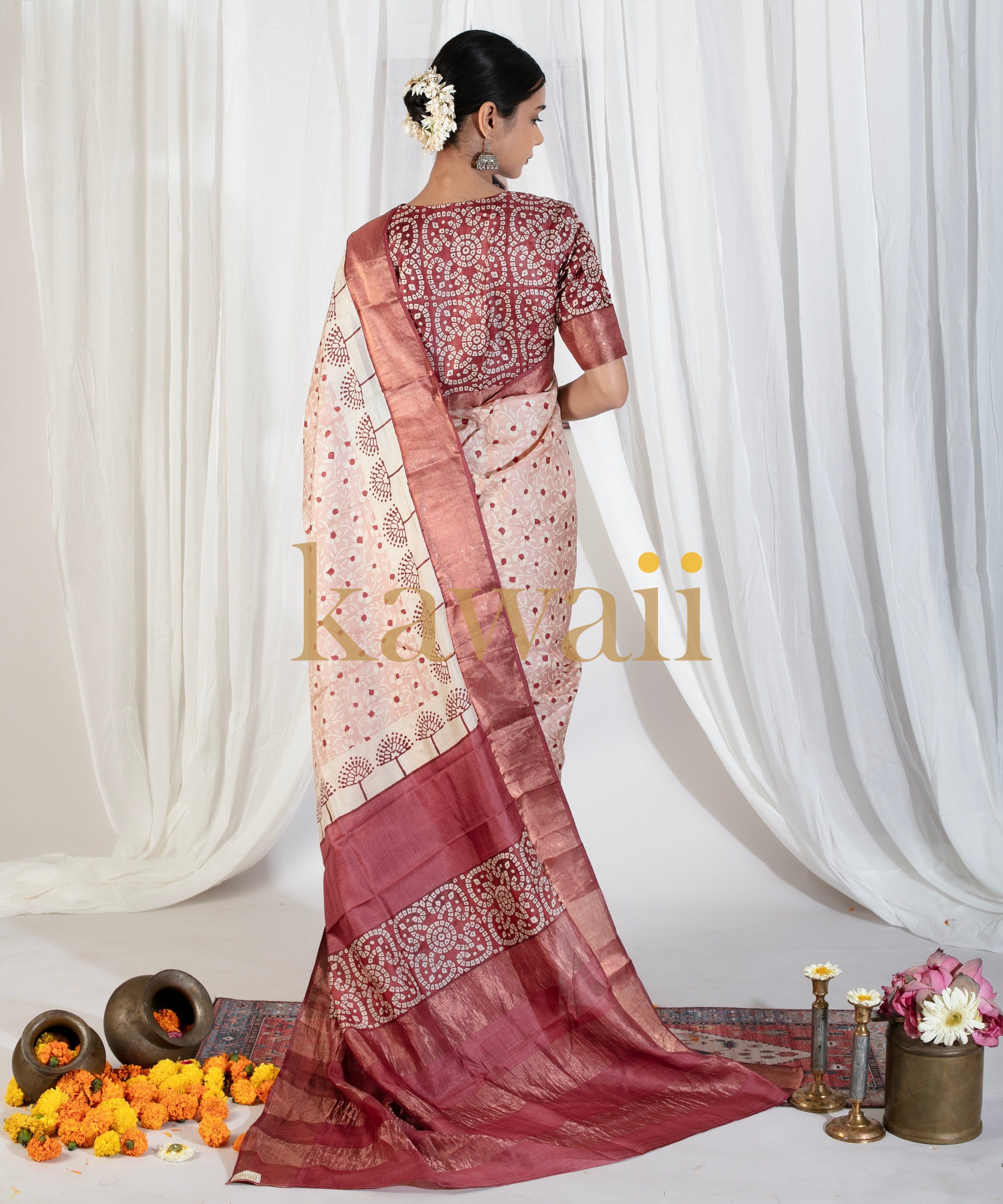 Elegant woman wearing a maroon and cream block print saree from Kawaii with intricate patterns