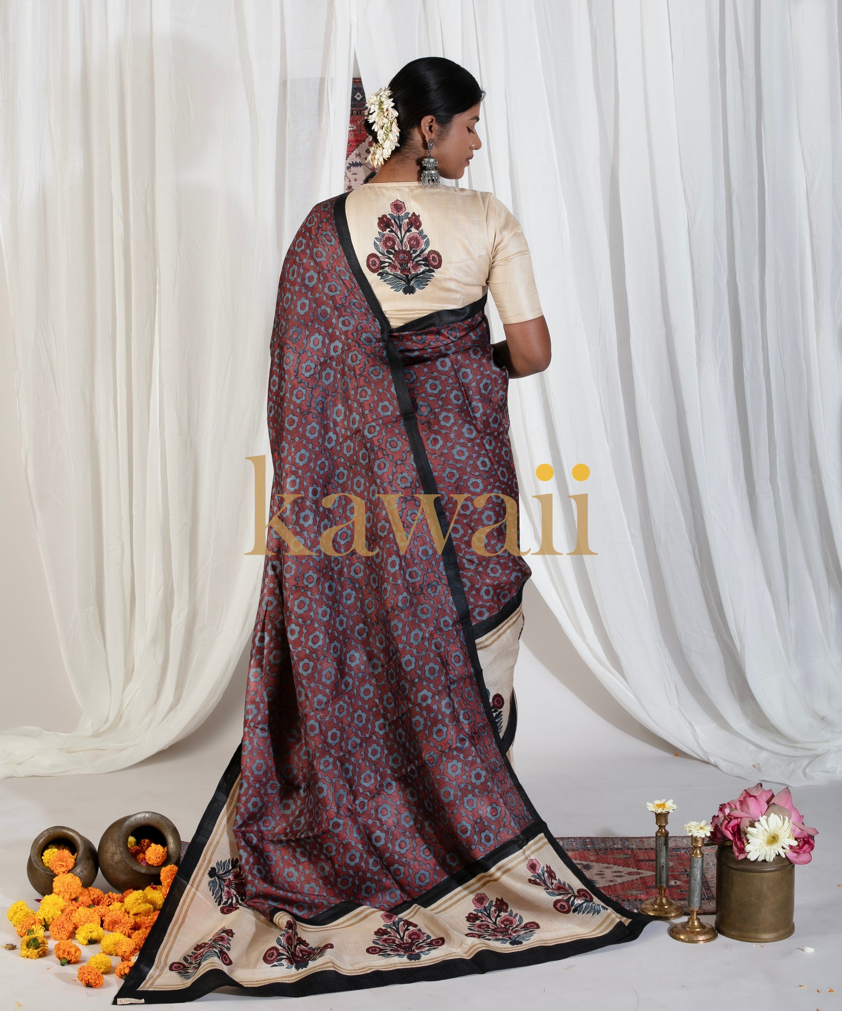Kawaii block print saree in maroon and beige with floral patterns worn by a woman with traditional accessories