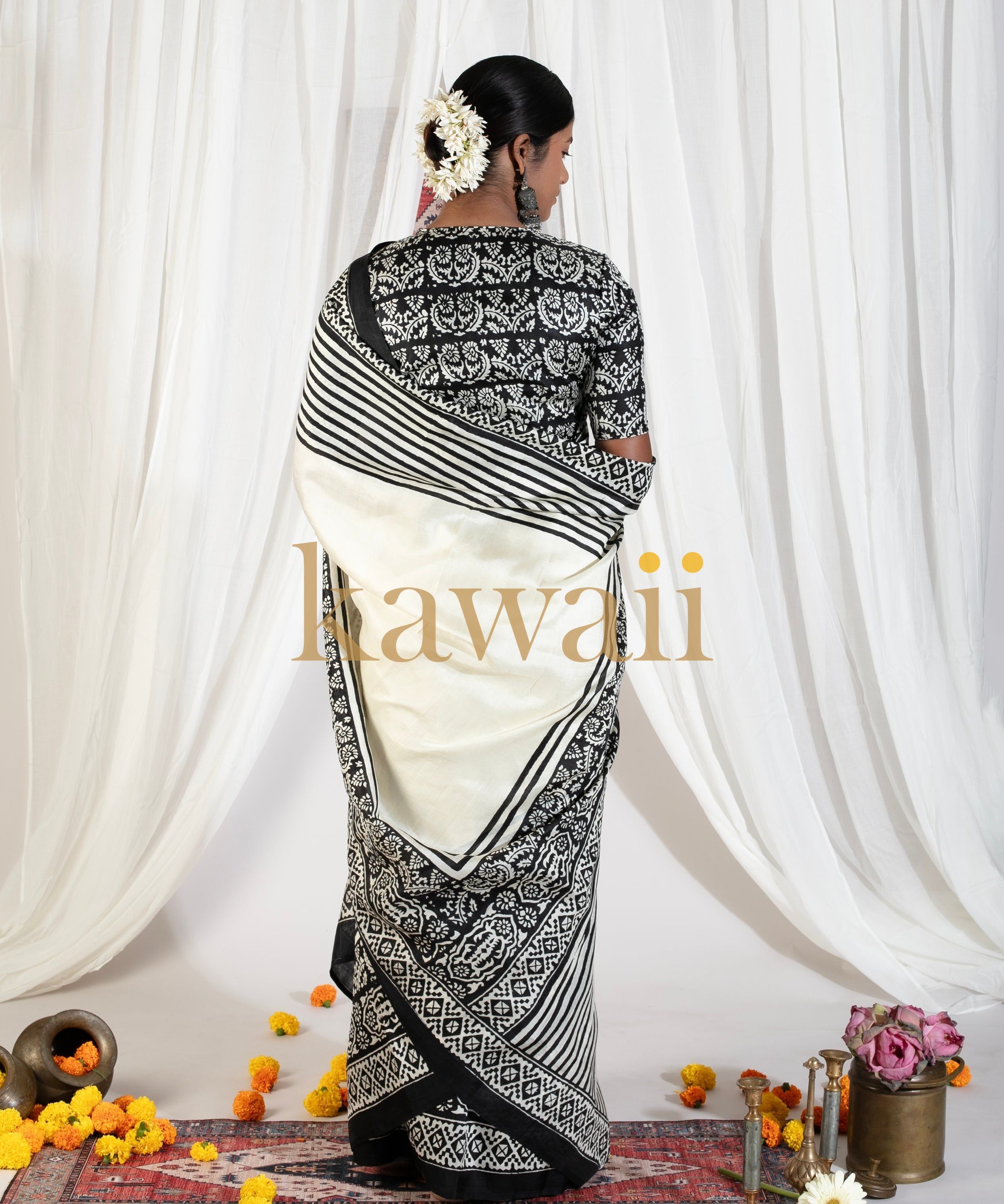 Woman wearing a black and white block print saree by Kawaii with floral hair accessories