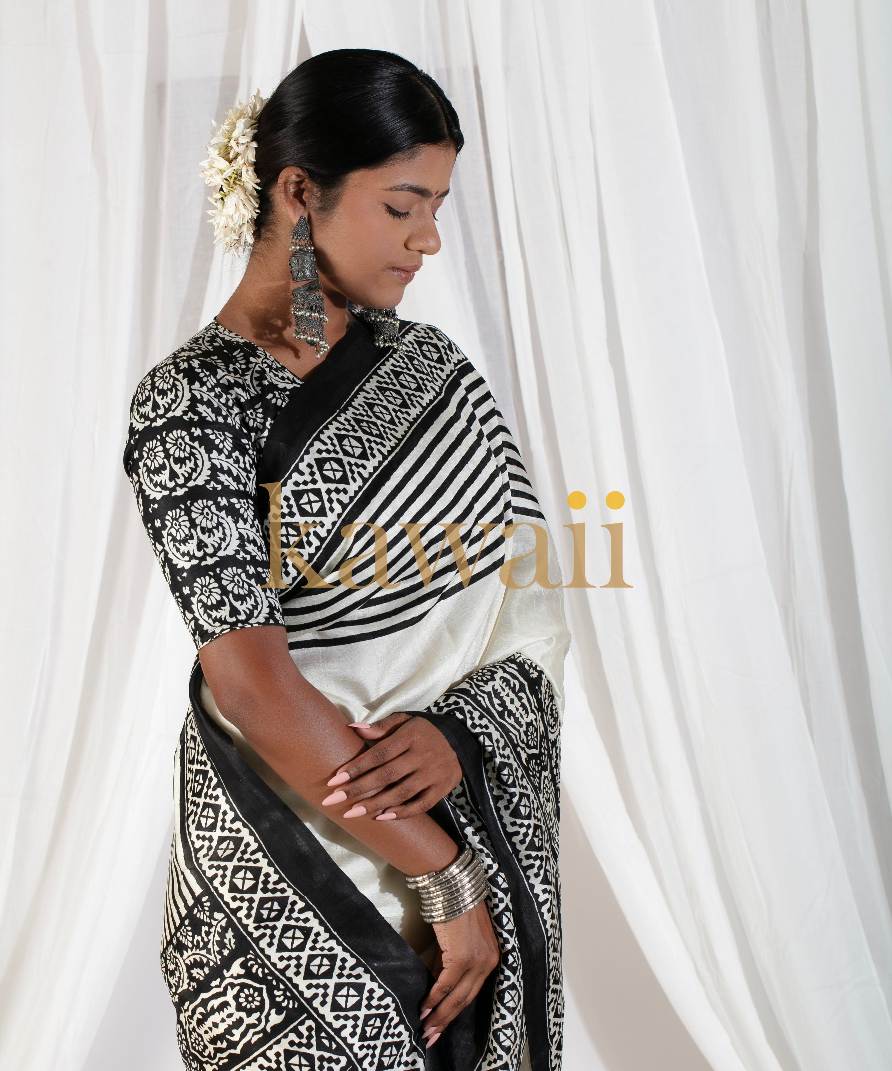 Elegant black and white block print saree by Kawaii worn by woman with traditional jewelry and floral hair accessory