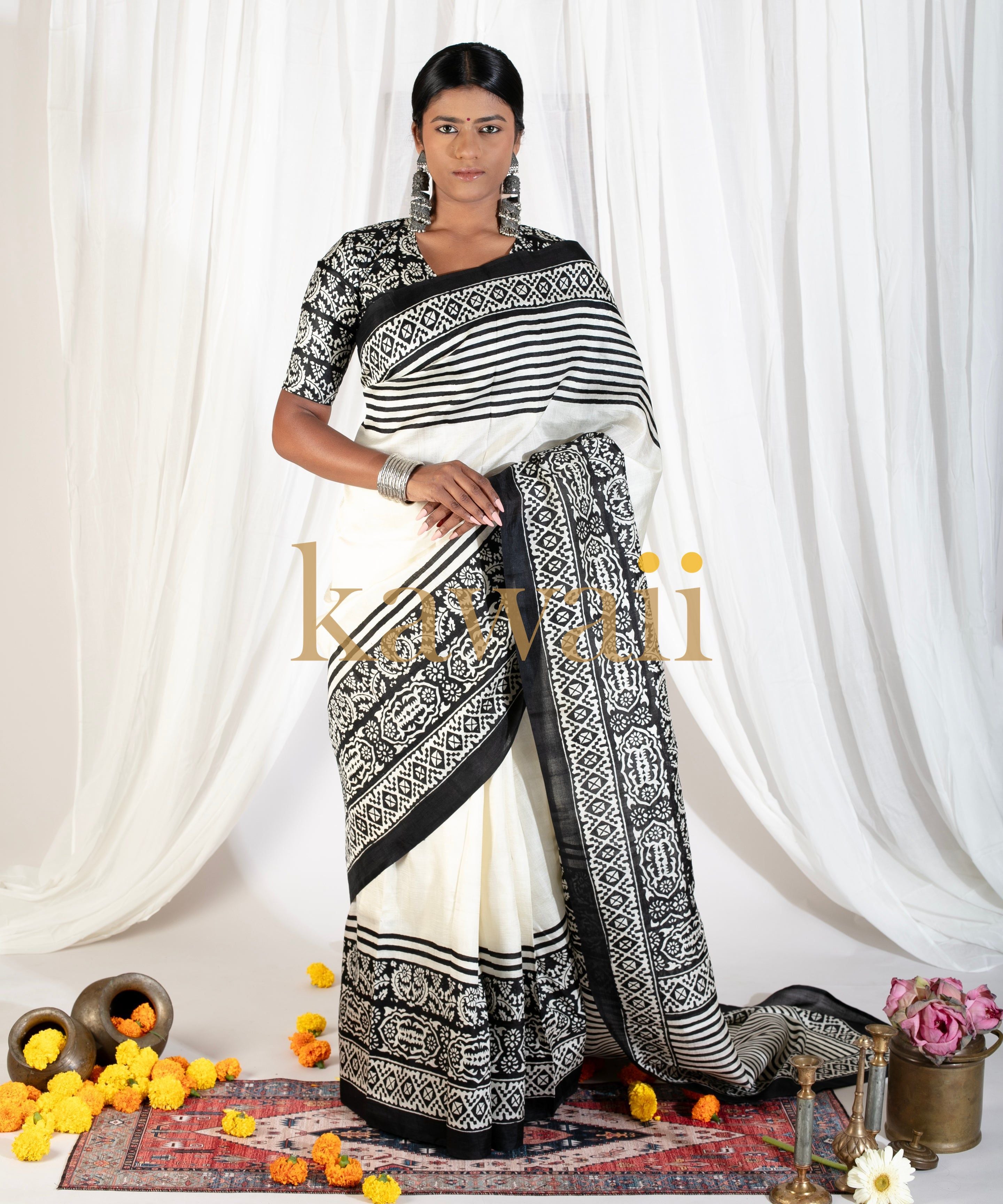 Elegant black and white block print saree by Kawaii worn by model against white draped background