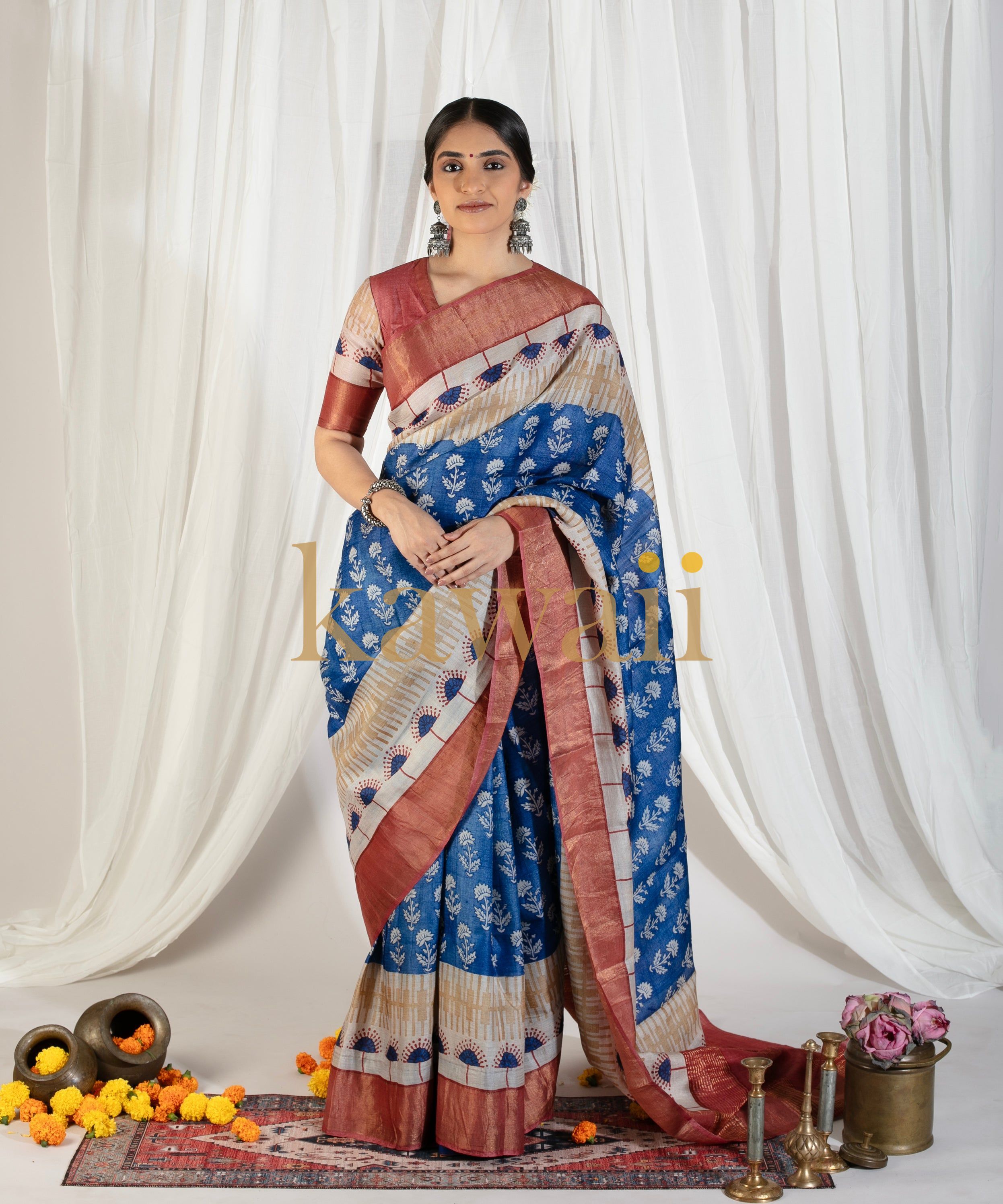 Kawaii blue and maroon block print saree worn by woman with traditional jewelry and floral decor