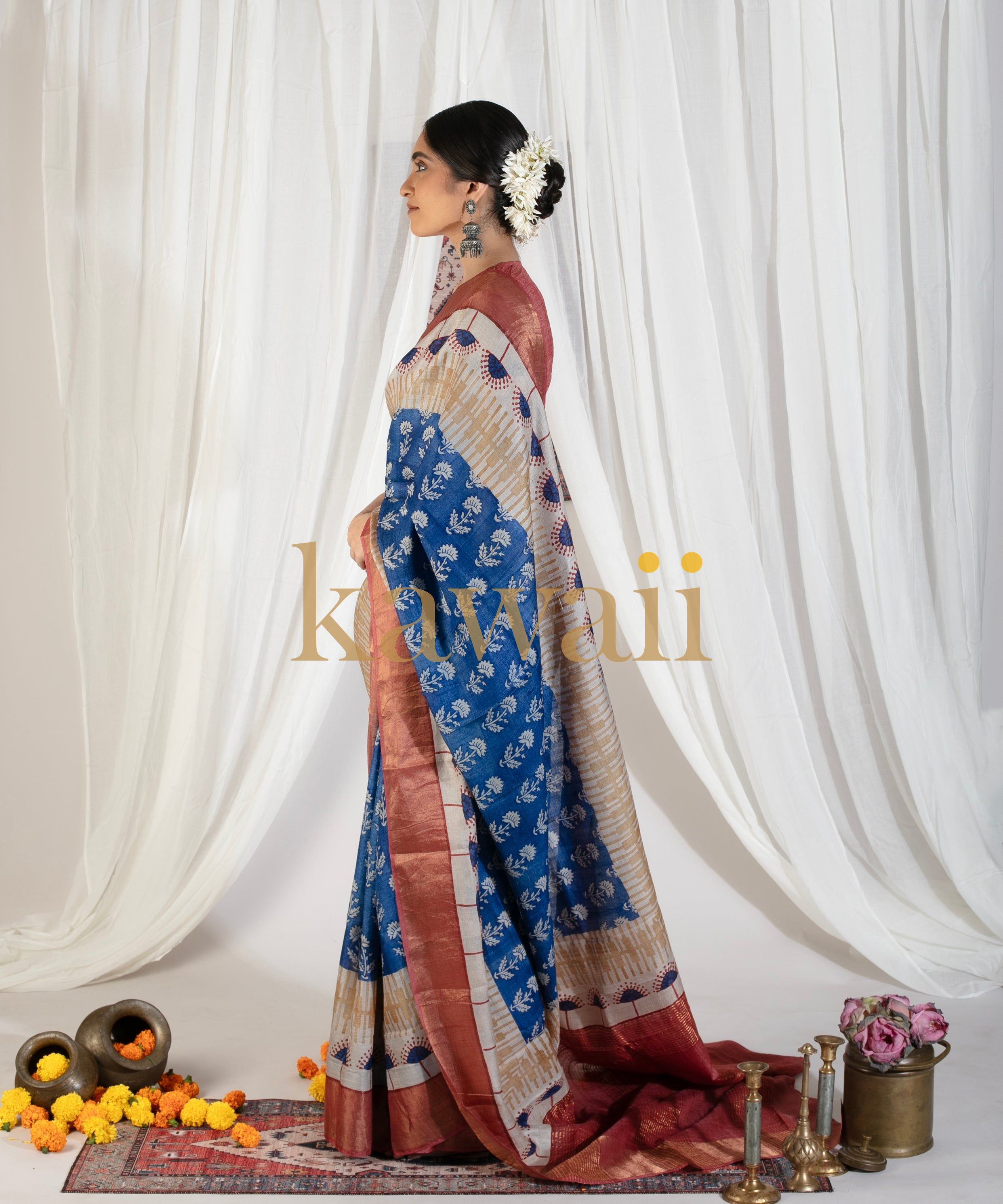Kawaii block print saree in blue and maroon with floral patterns worn by woman with traditional hair accessories
