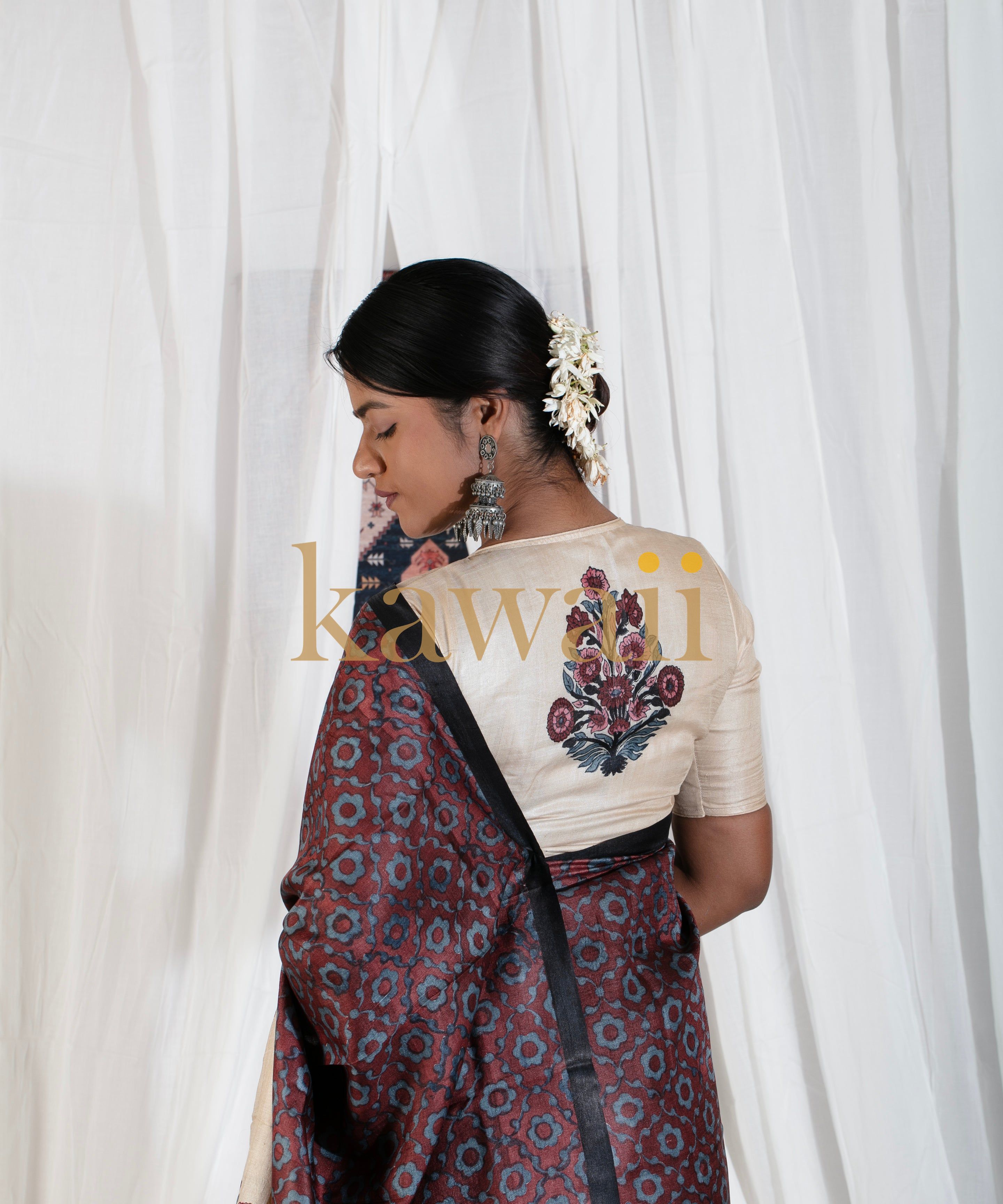 Woman wearing Kawaii's elegant block print saree with floral patterns and cream blouse with embroidered back