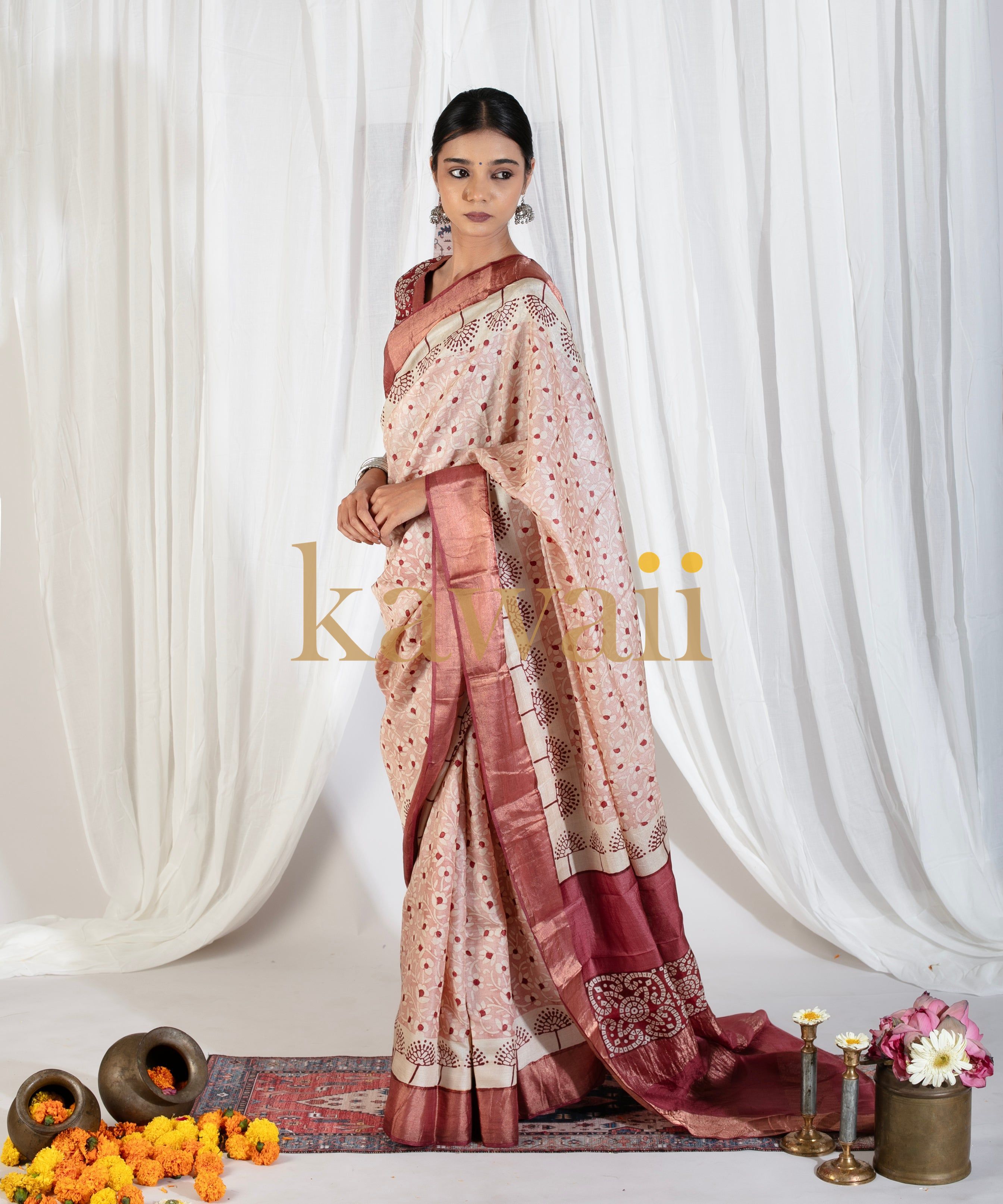 Elegant beige and maroon block print saree worn by model with traditional floral patterns