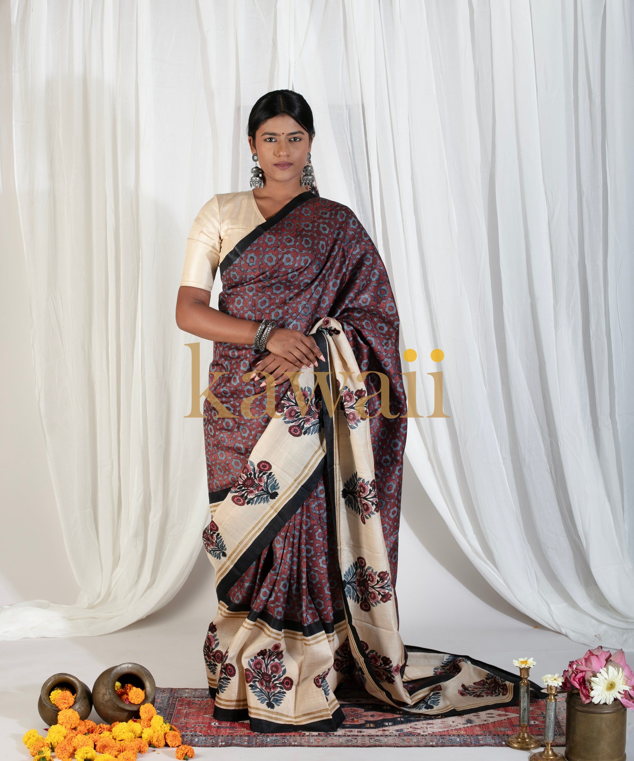 Kawaii block print saree in maroon and cream with floral motifs worn by a woman with traditional jewelry