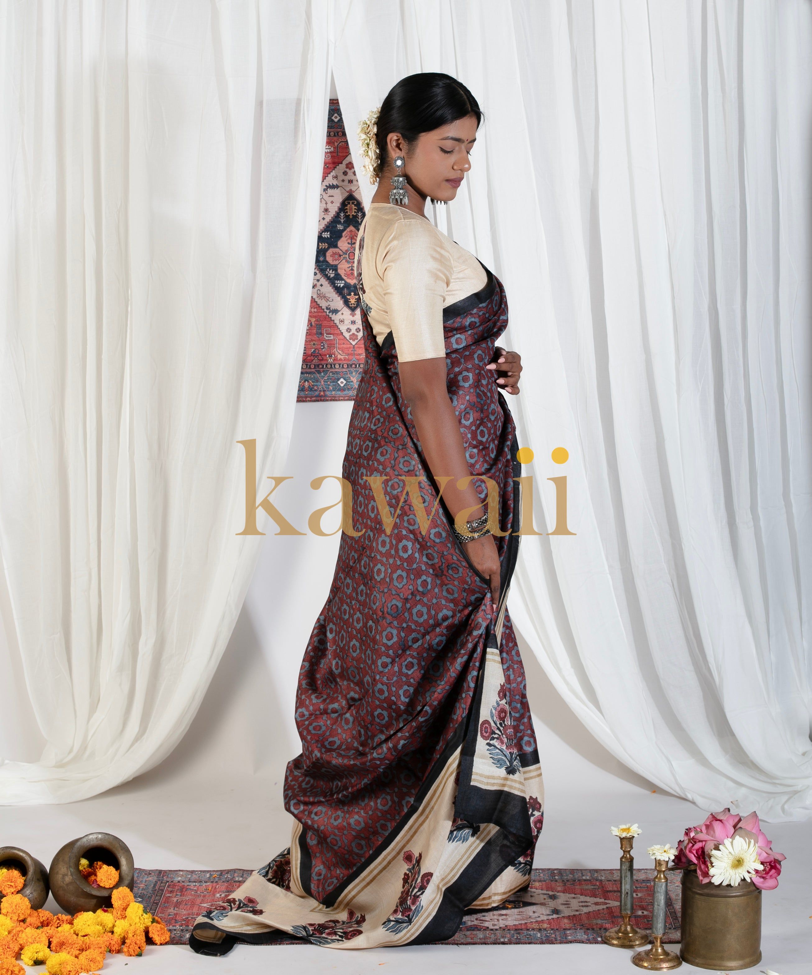 Woman wearing a dark patterned block print saree by Kawaii with beige blouse and traditional jewelry