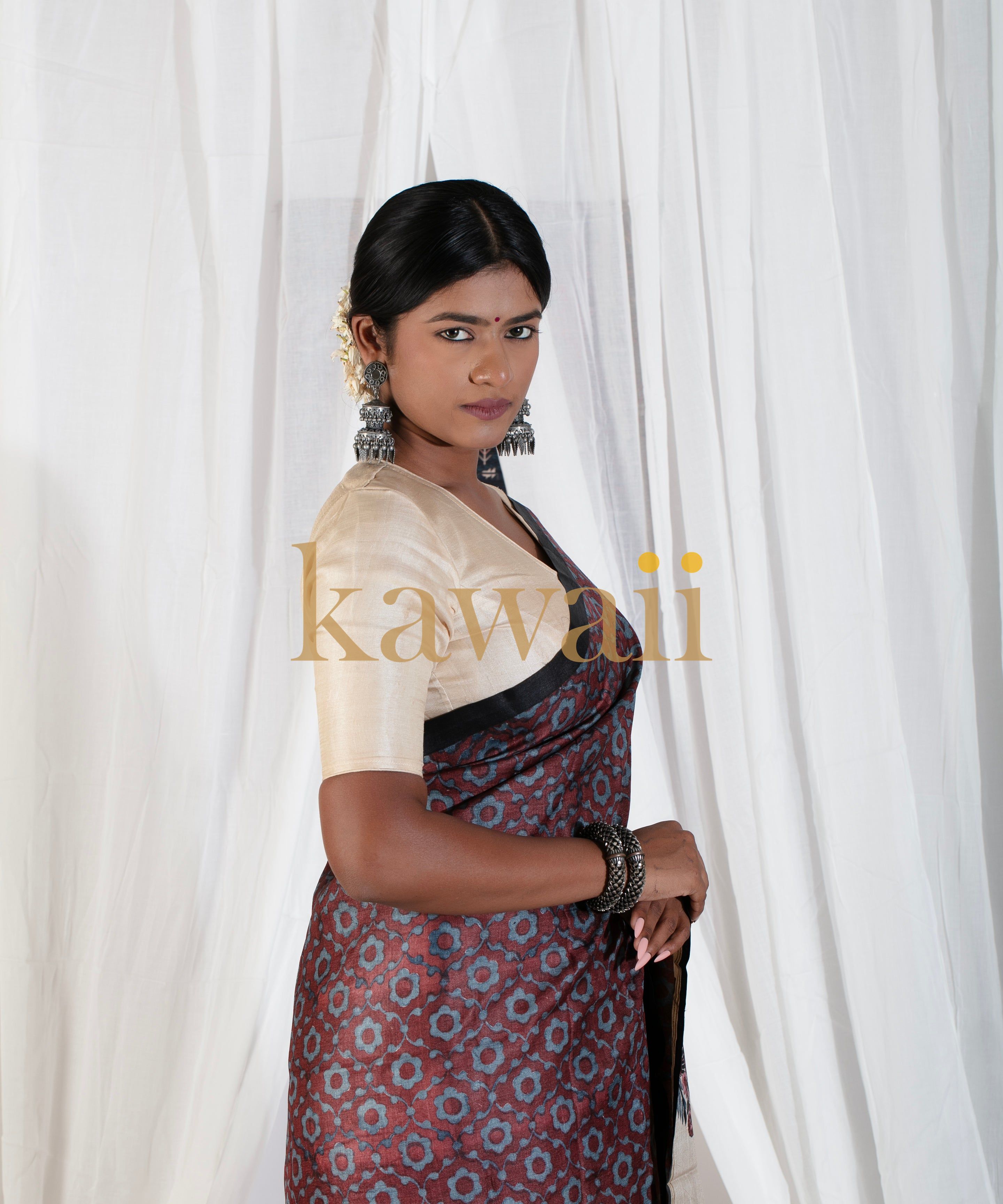 Kawaii block print saree in maroon with geometric patterns worn with beige blouse and traditional jewelry