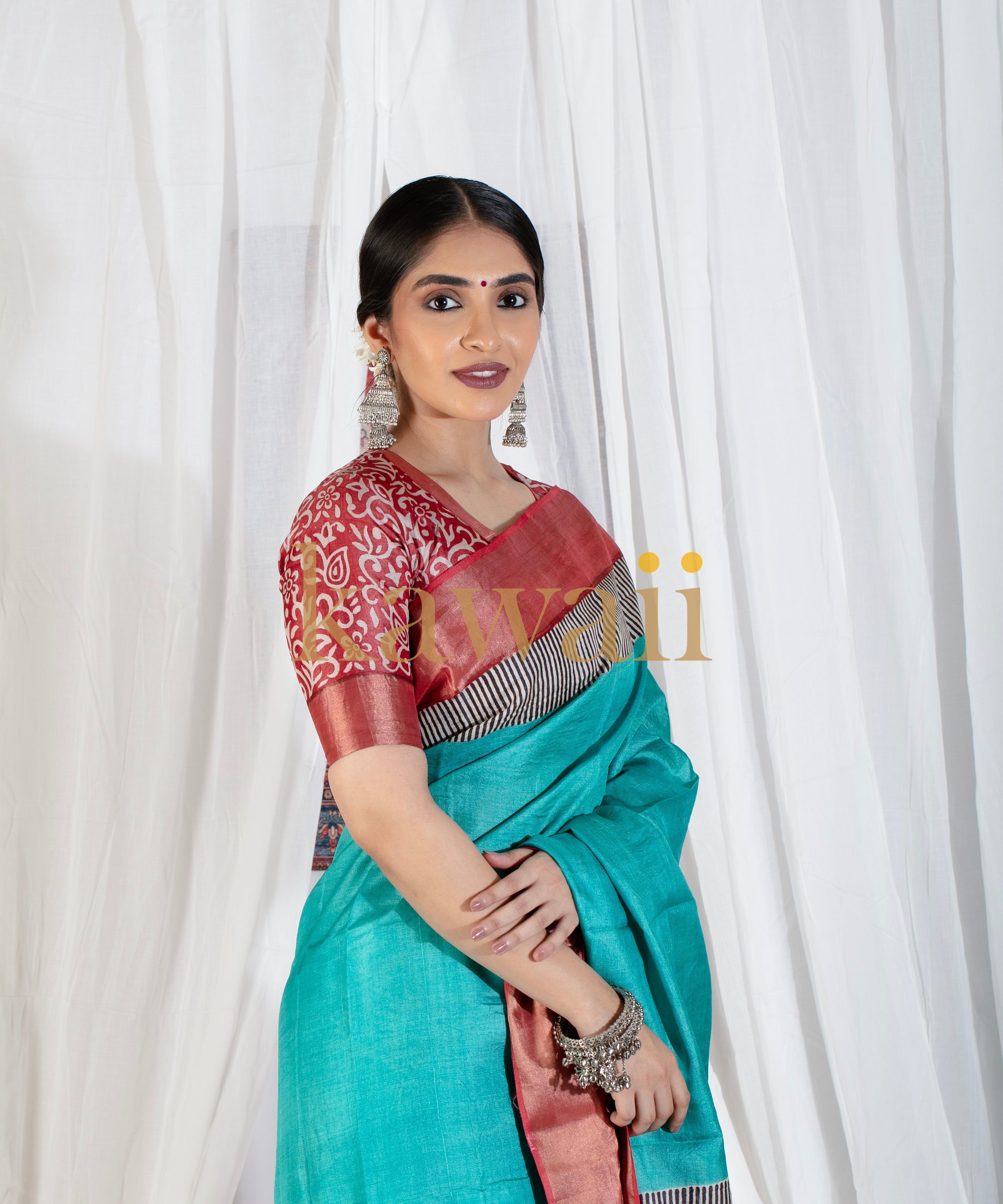 Woman wearing a turquoise block print saree with red and black patterned blouse by Kawaii