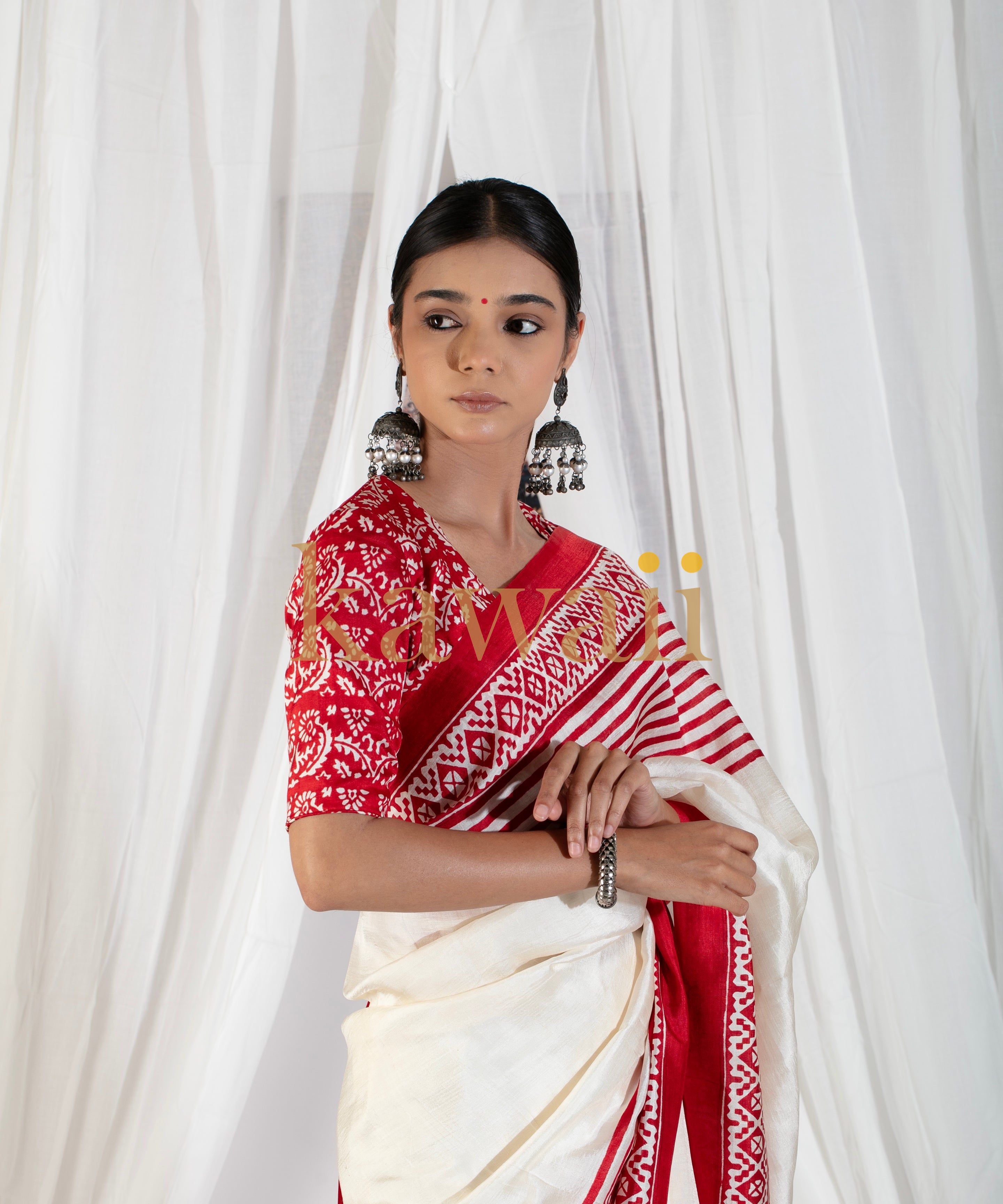 Woman wearing red and white block print saree with matching blouse and silver jhumka earrings