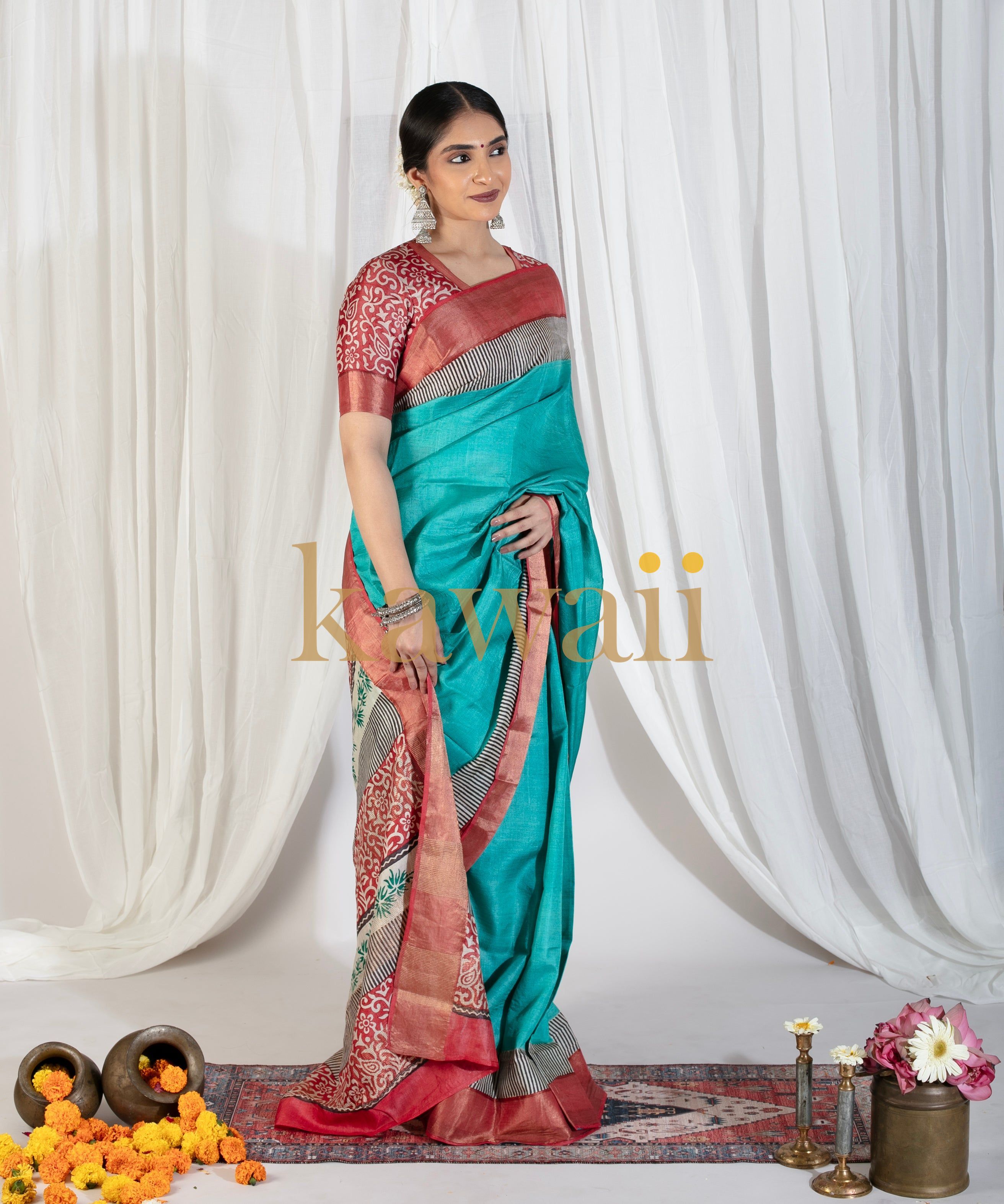 Kawaii block print saree in teal blue with red and gray border worn by a model with traditional jewelry