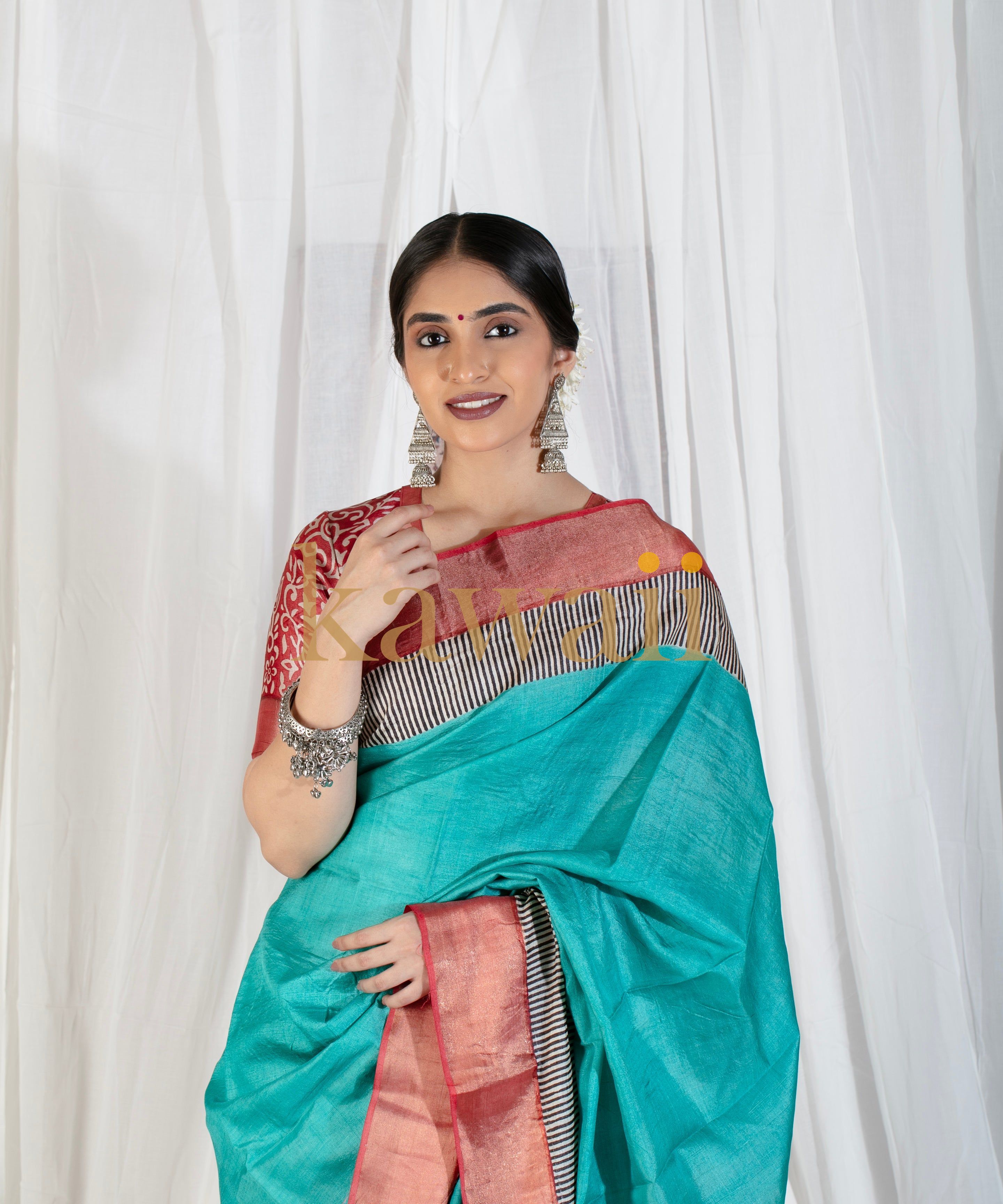 Woman wearing Kawaii block print saree in turquoise with red and black patterned blouse