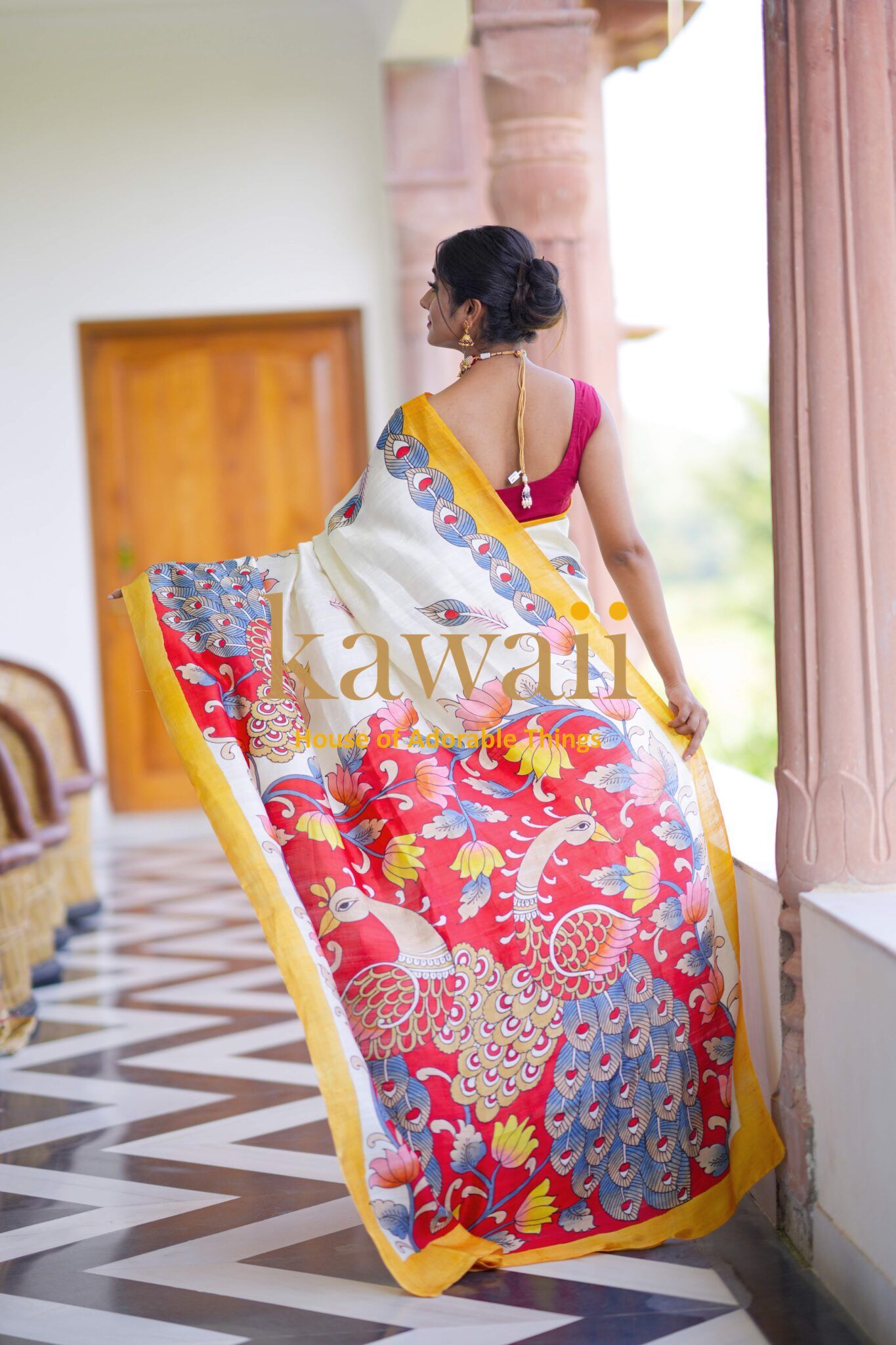 Kawaii kalamkari saree featuring vibrant peacock and floral designs in red and yellow borders
