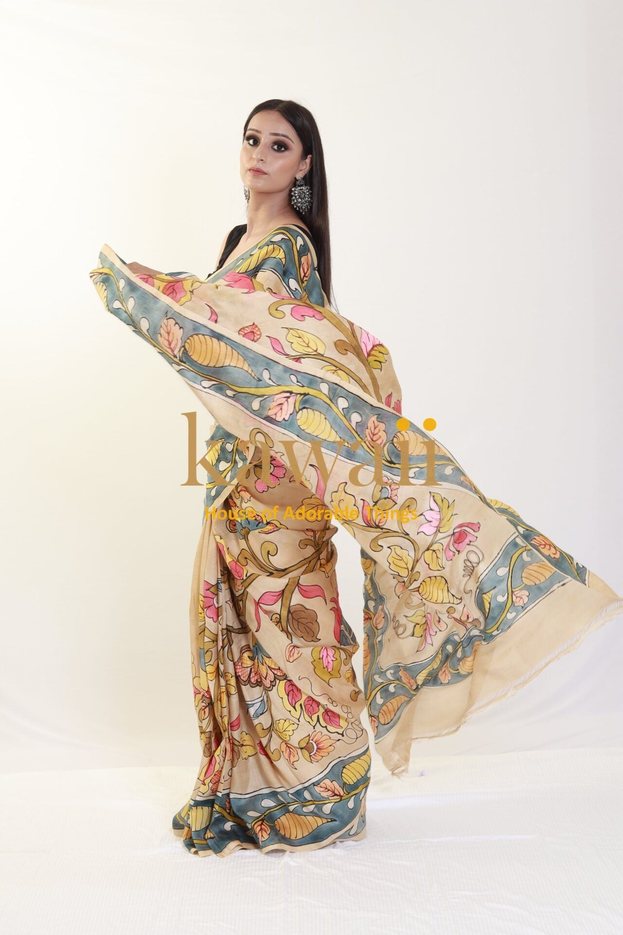 Kawaii kalamkari saree in beige with floral and leaf patterns worn by a model with long earrings