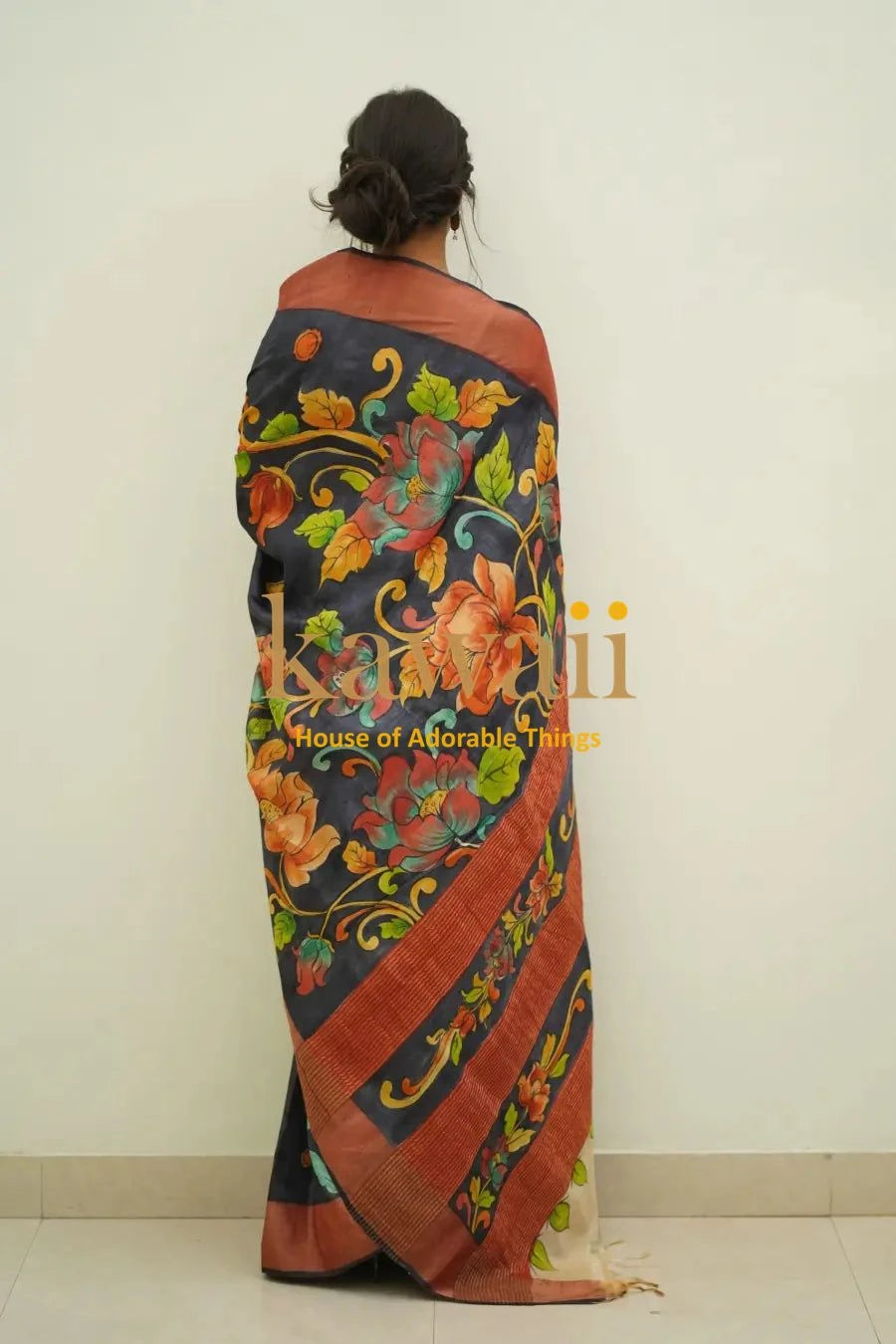Kawaii kalamkari saree with vibrant floral patterns in orange and green on black background