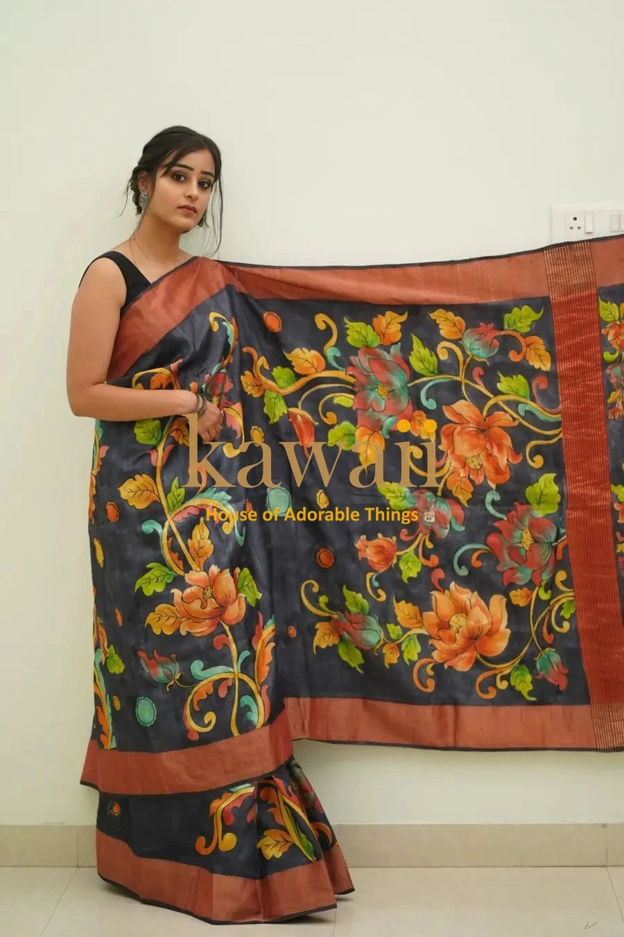 Kawaii black and brown kalamkari saree with vibrant floral patterns worn by a woman