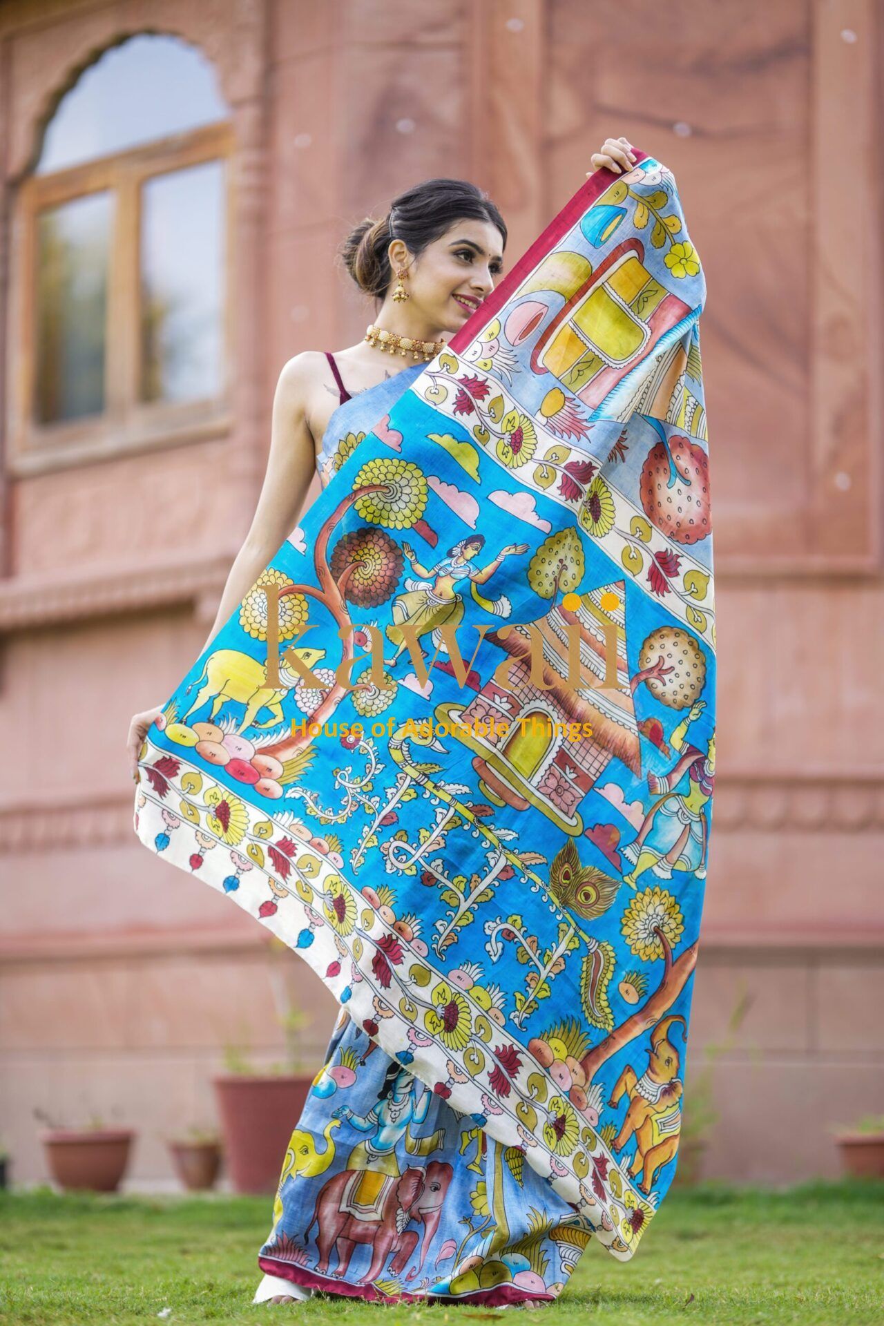 Kawaii kalamkari saree in vibrant blue with traditional motifs worn by woman outdoors