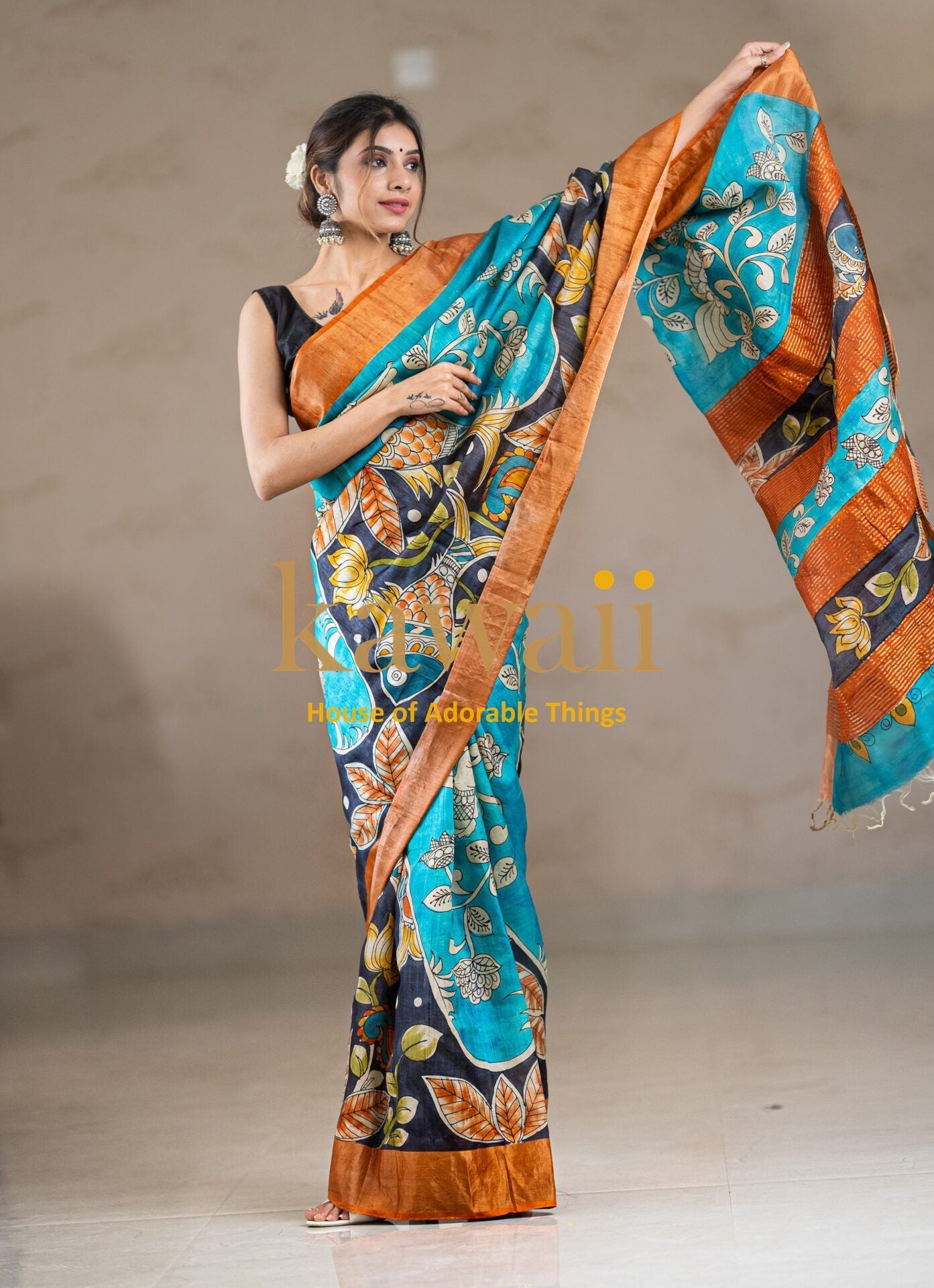 Kawaii kalamkari saree in teal and orange with traditional floral patterns worn by woman