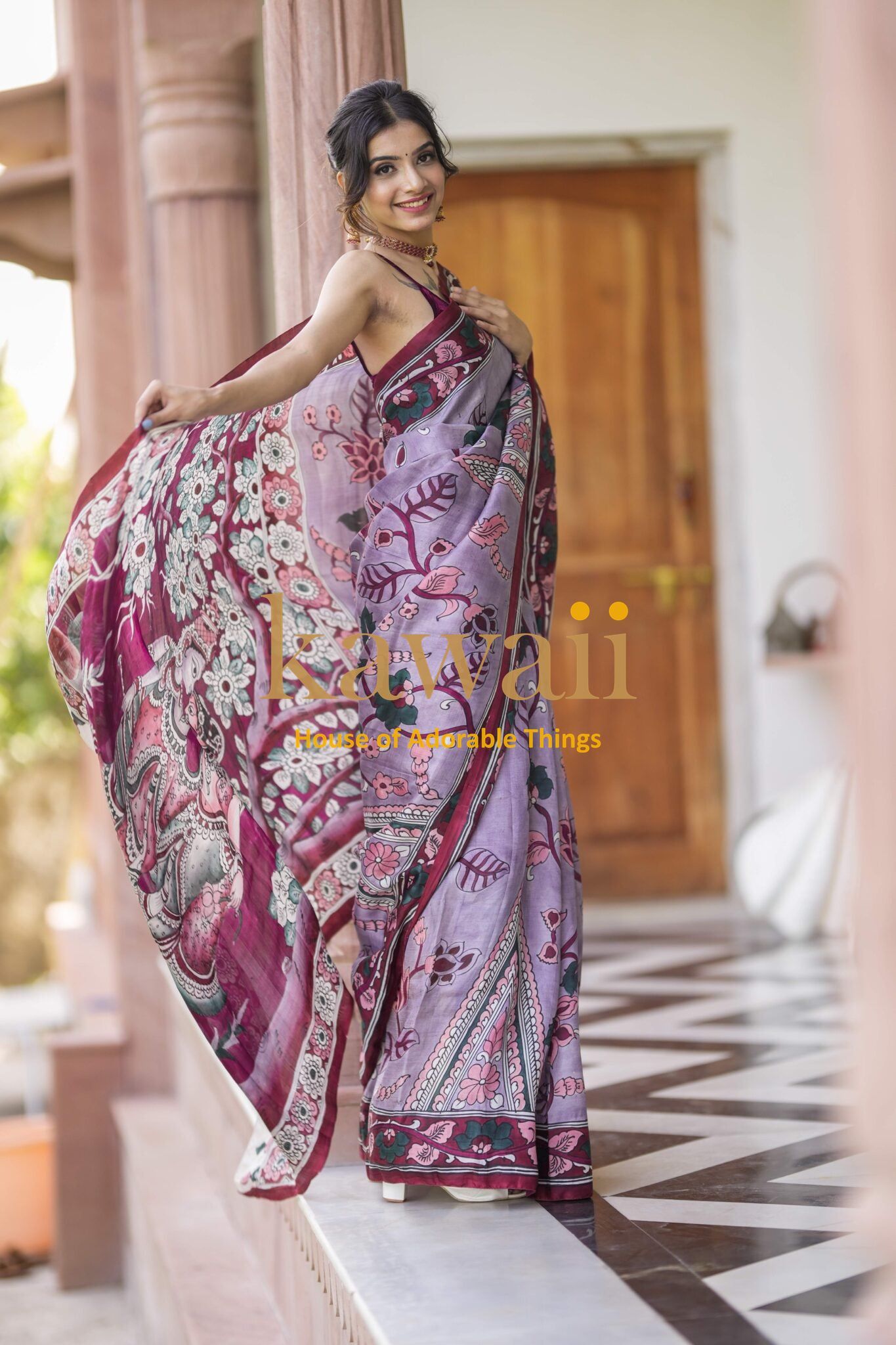 Kawaii kalamkari saree with intricate floral and bird patterns worn by smiling woman indoors
