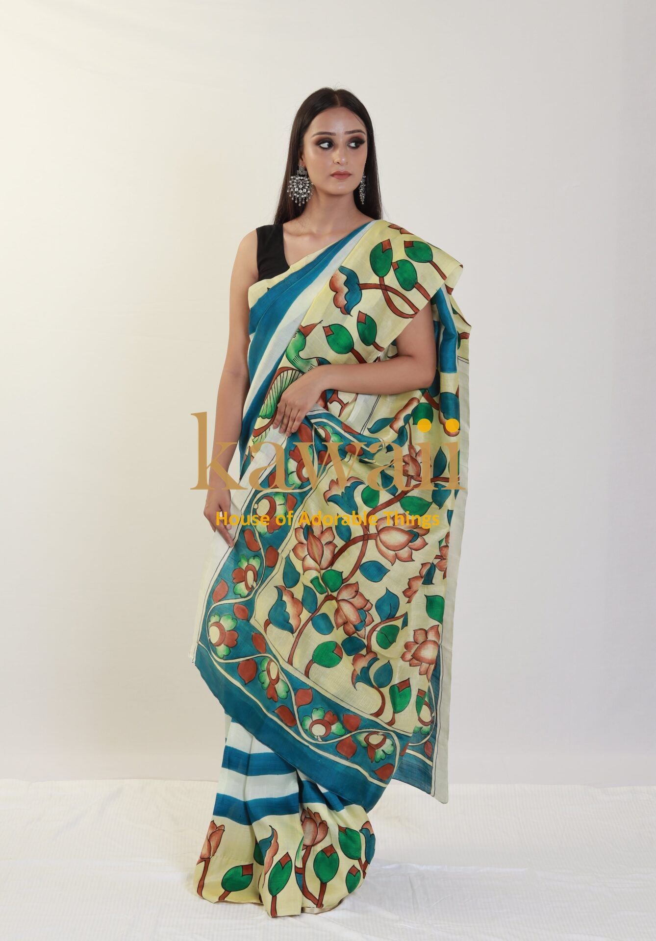 Kawaii kalamkari saree with floral and leaf patterns in cream and teal colors worn by model