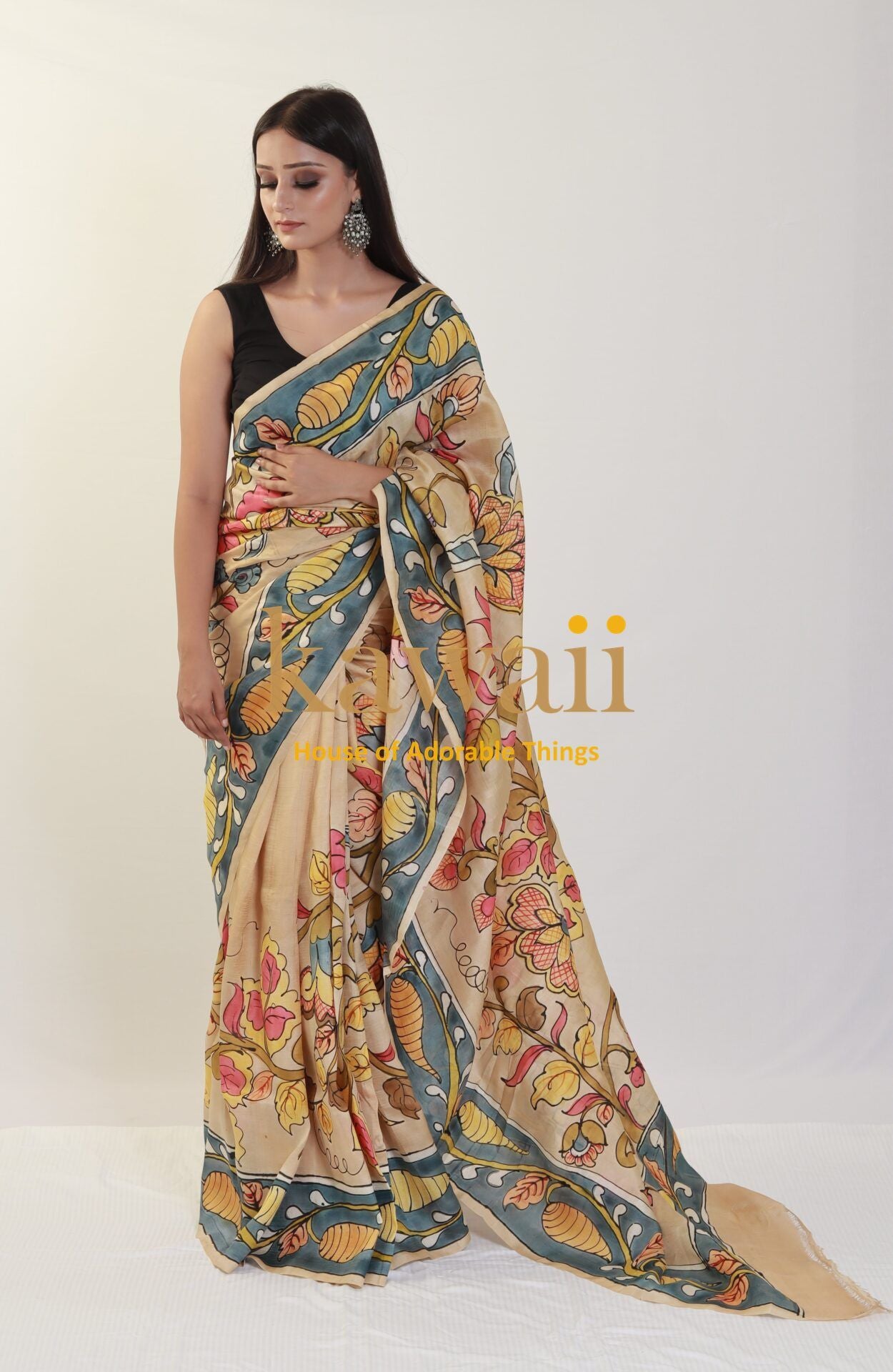Kawaii kalamkari saree with floral and leaf patterns in beige and blue worn by a woman with black blouse