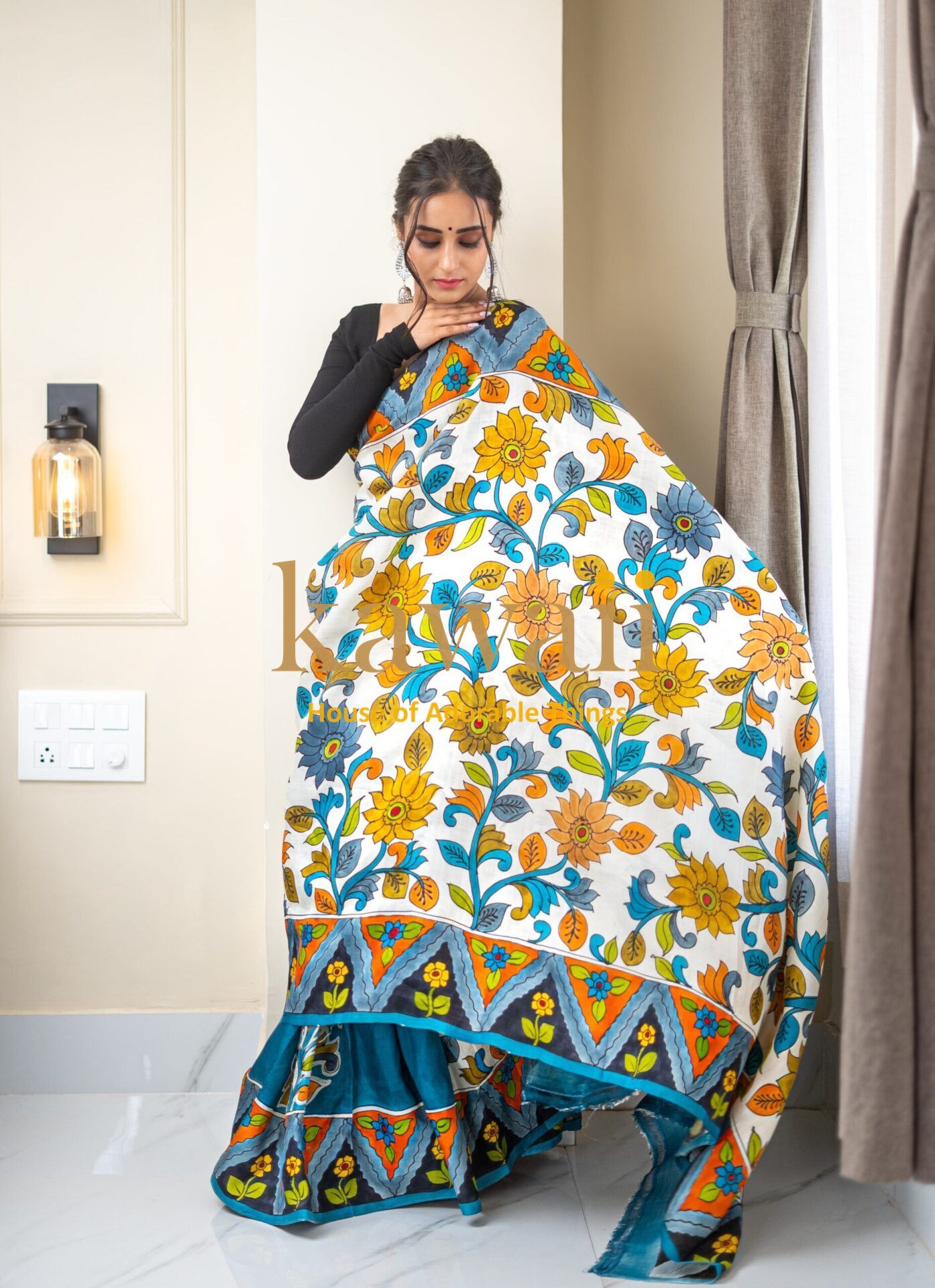 Kawaii kalamkari saree with vibrant floral patterns in blue yellow and orange worn by woman
