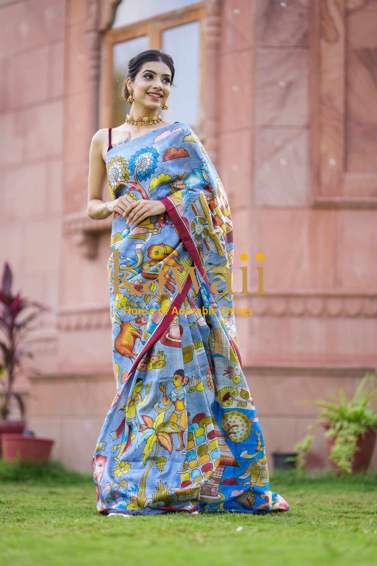 Kawaii kalamkari saree with colorful traditional Indian art prints worn by a smiling woman outdoors