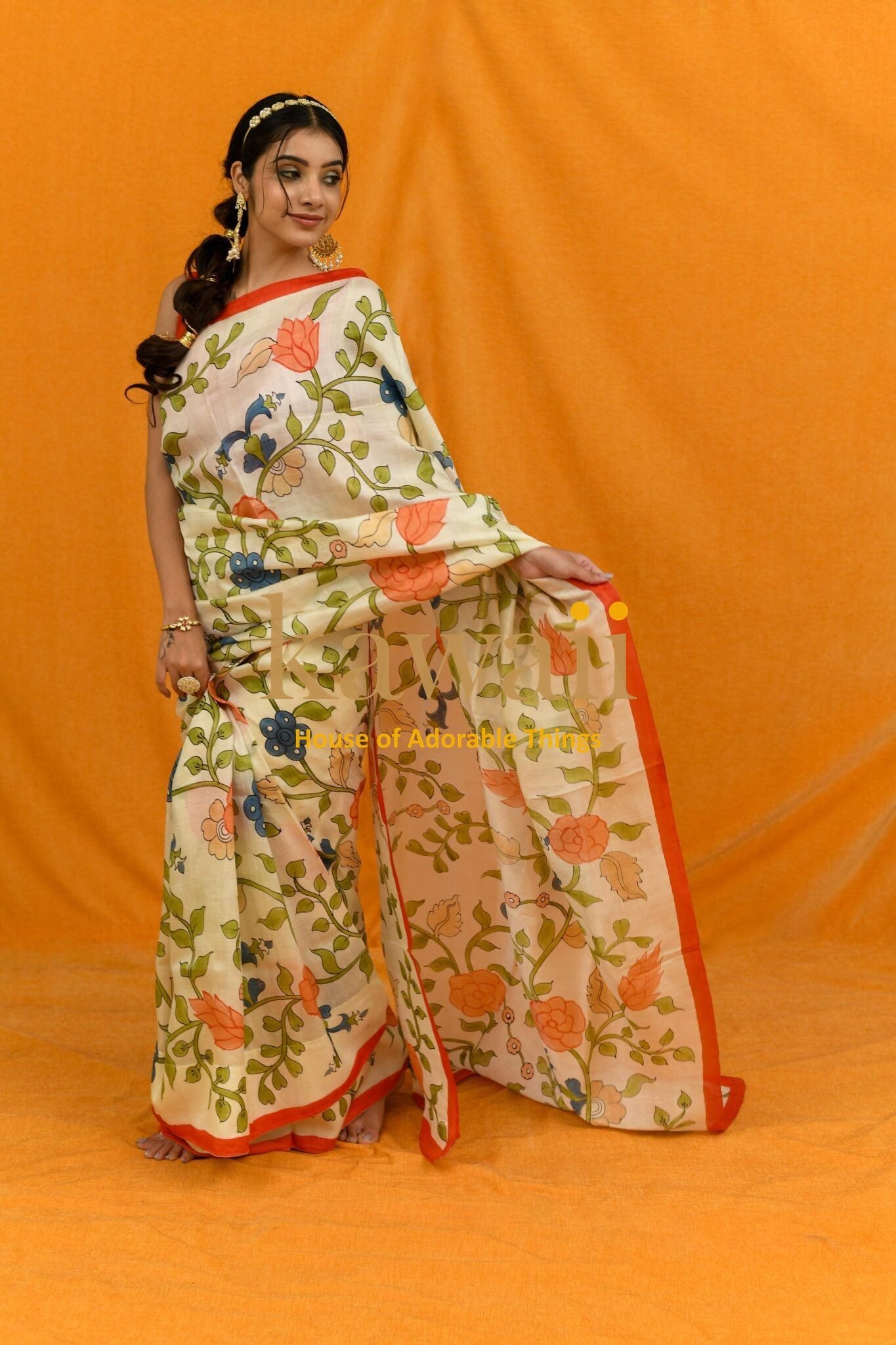 Kawaii kalamkari saree online with floral handcrafted sarees in India worn by model on orange background