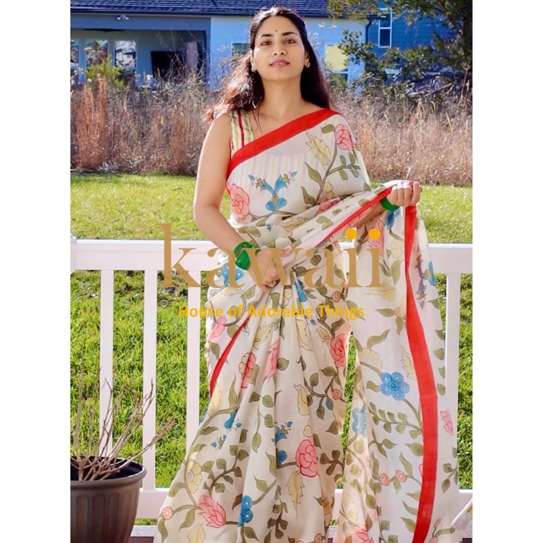 Kawaii handcrafted kalamkari saree online with floral patterns and red border worn by woman outdoors
