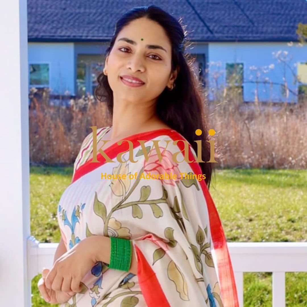 Woman wearing a Kawaii kalamkari saree online with floral design and red border handcrafted sarees in india