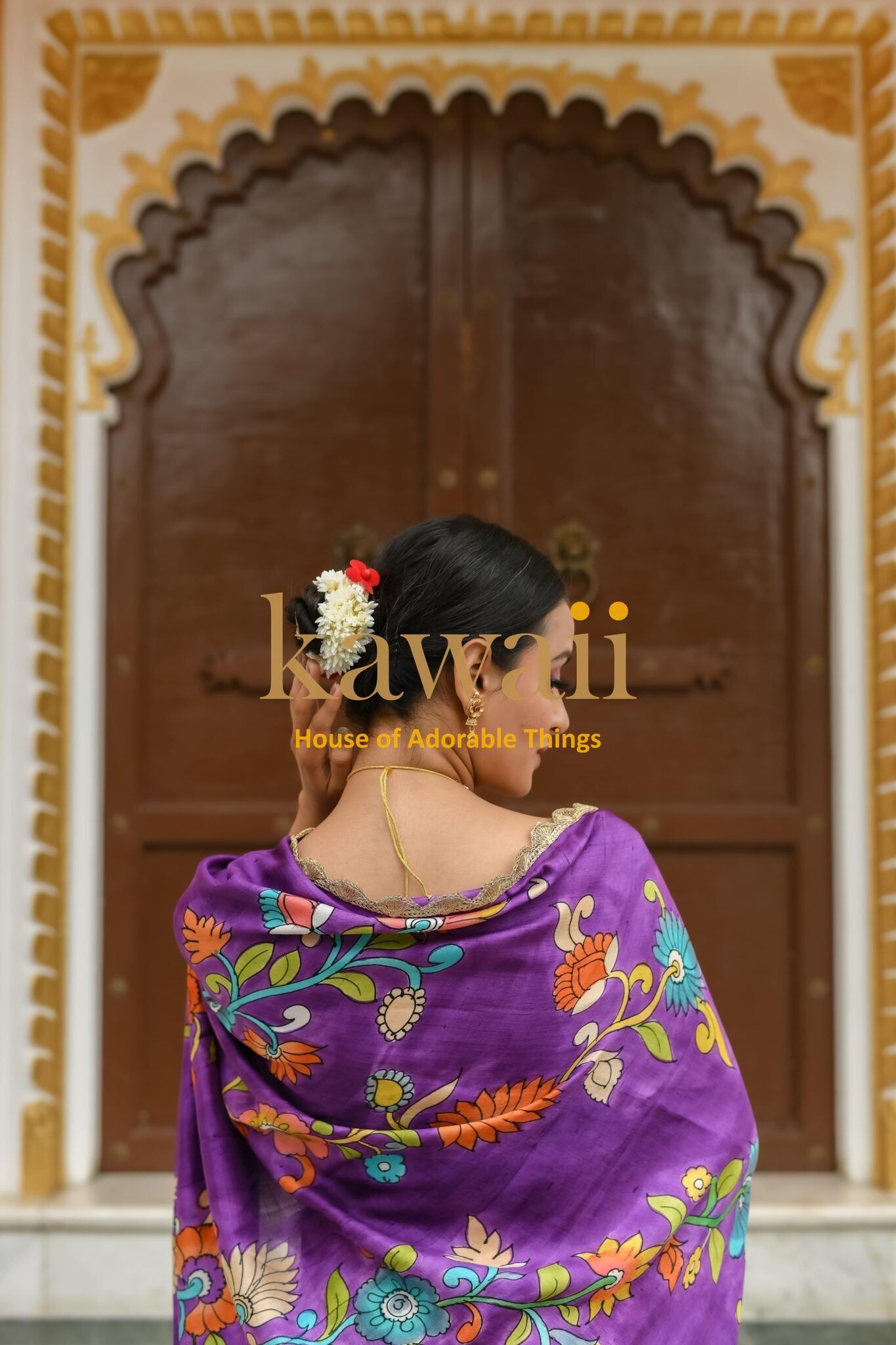 Woman draped in vibrant purple kalamkari saree with floral patterns from Kawaii brand