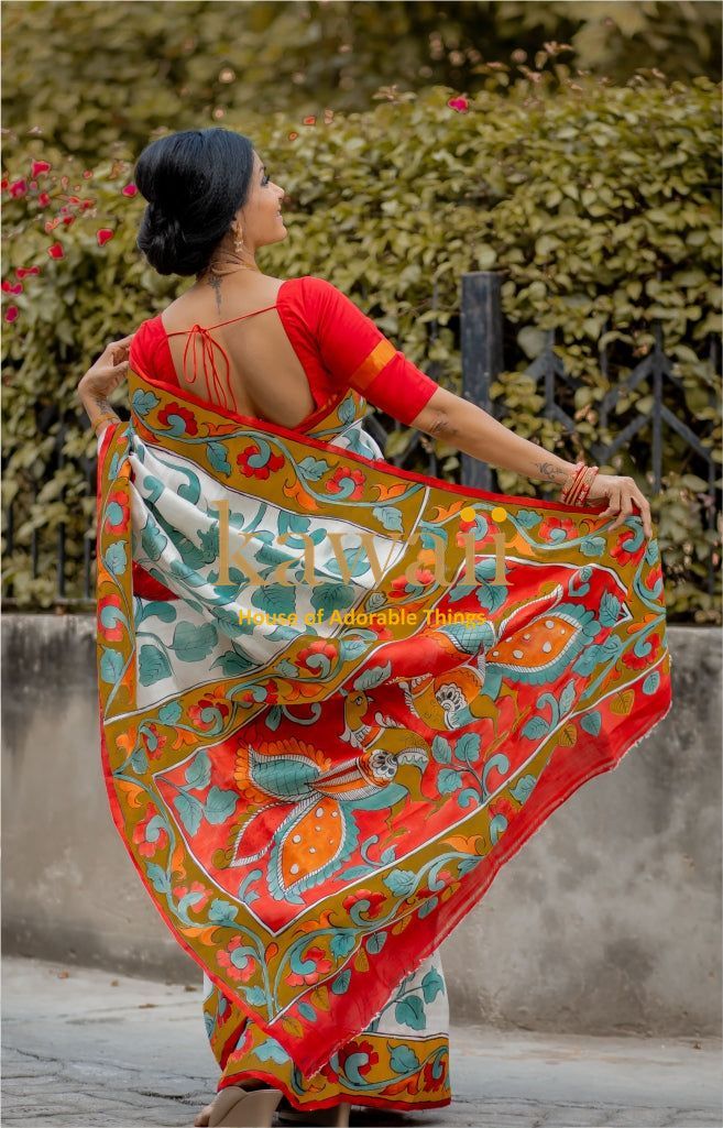 Woman wearing colorful kalamkari saree with rich traditional patterns and red blouse outdoors