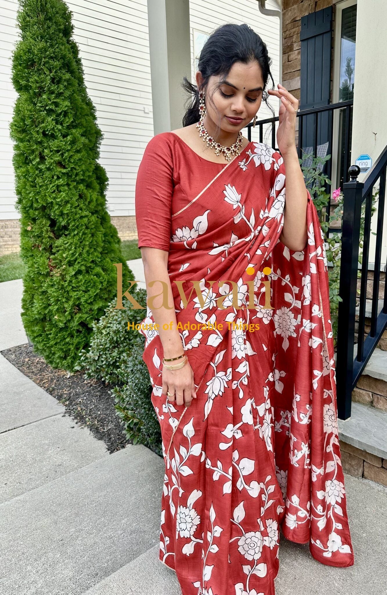 Kawaii kalamkari saree in red with white floral patterns worn by woman with matching blouse and jewelry