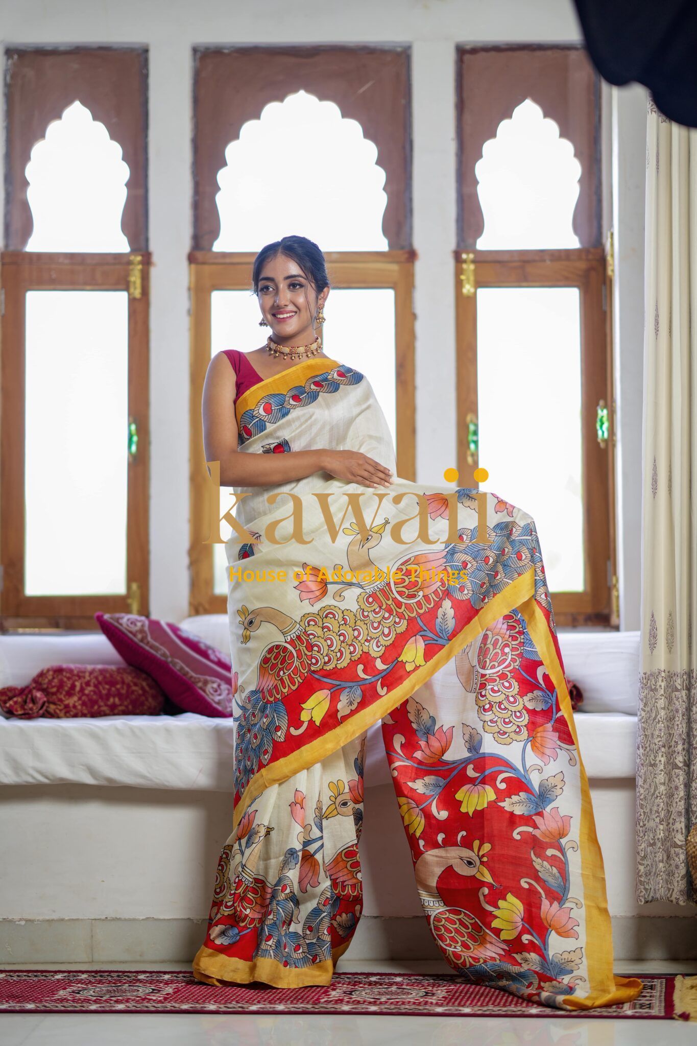 Kawaii brand kalamkari saree featuring traditional floral and bird patterns in vibrant red, blue, and yellow hues