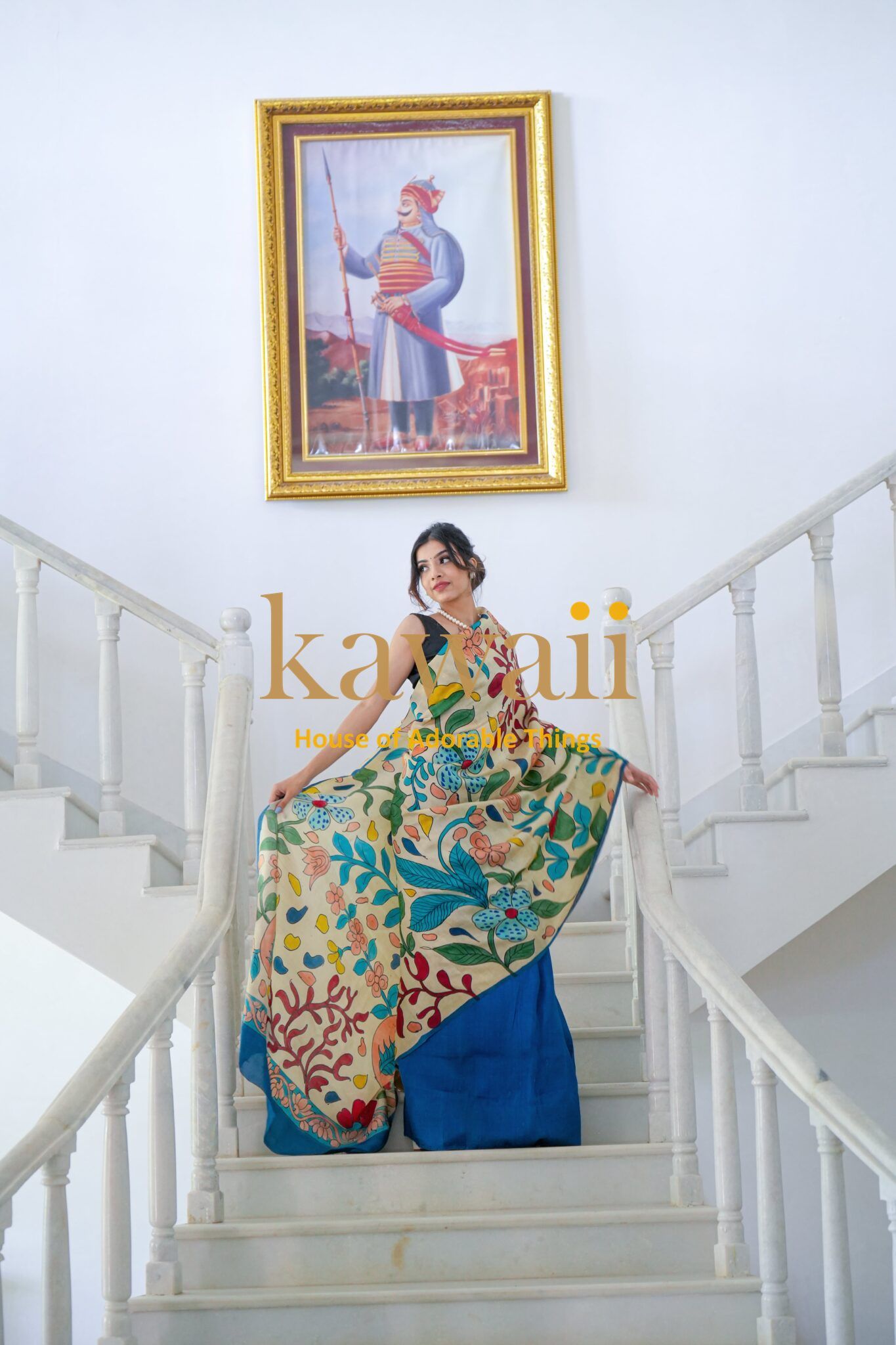 Kawaii kalamkari saree with vibrant floral and leaf patterns worn by woman on staircase