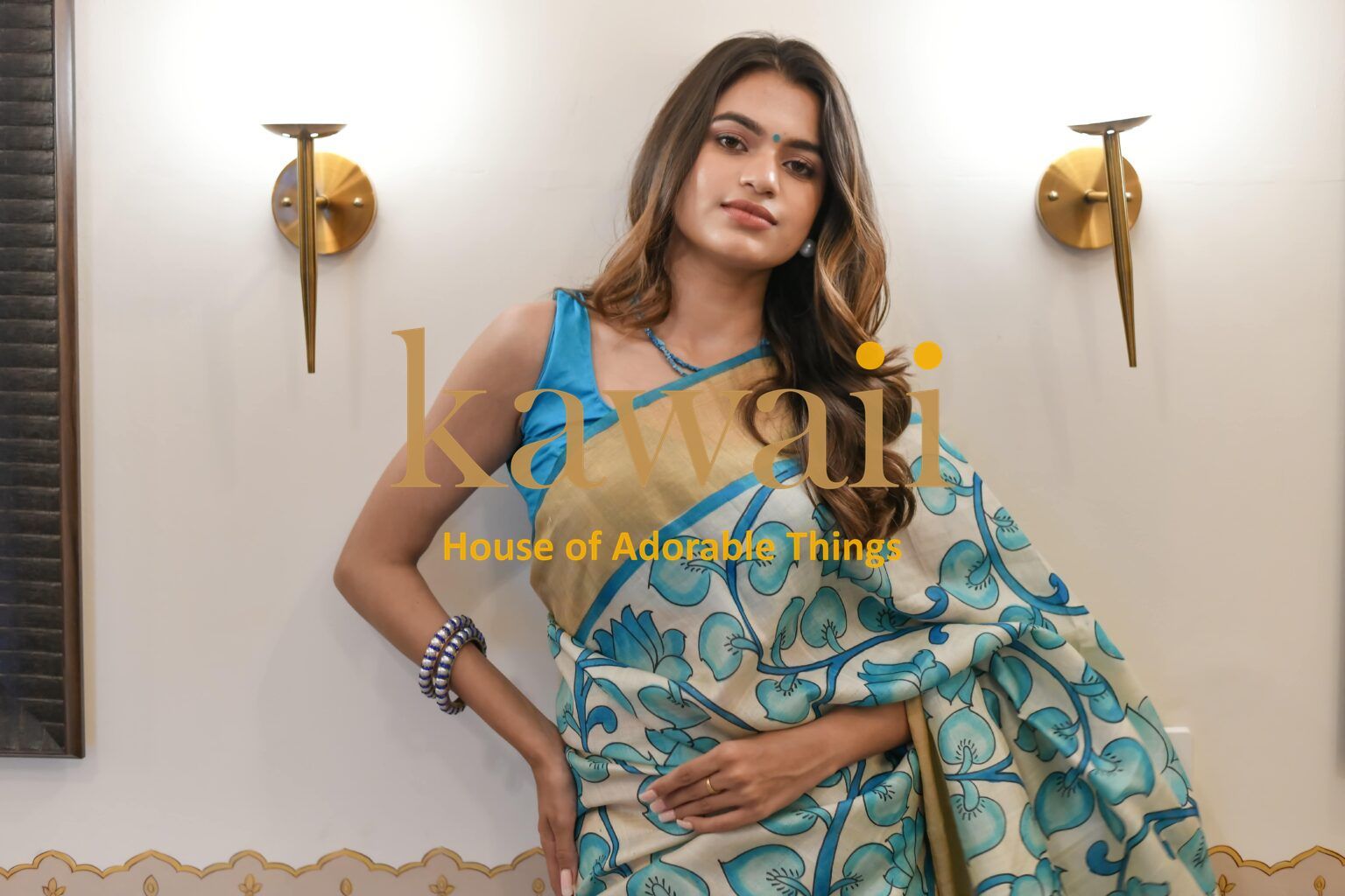 Kawaii kalamkari saree in blue and beige with floral patterns worn by a woman indoors