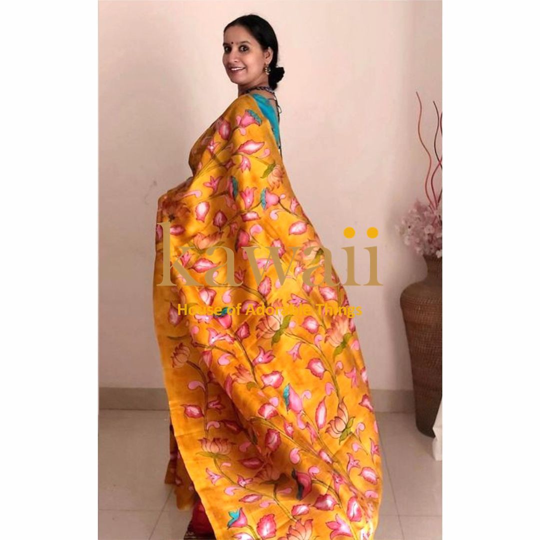 Woman wearing a vibrant yellow kalamkari saree with pink and blue floral patterns by Kawaii