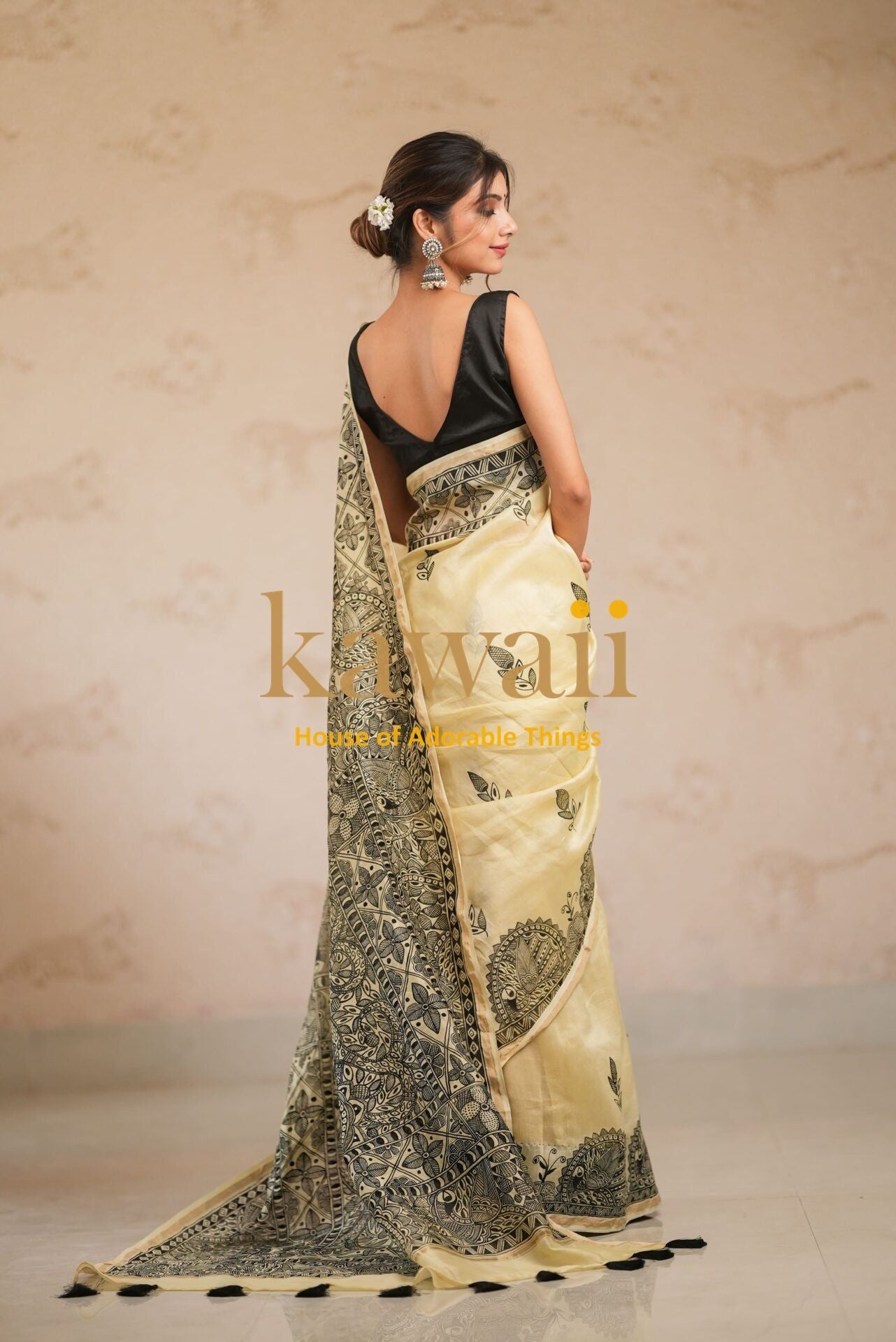 Elegant Madhubani saree with intricate black patterns on beige fabric draped by a woman