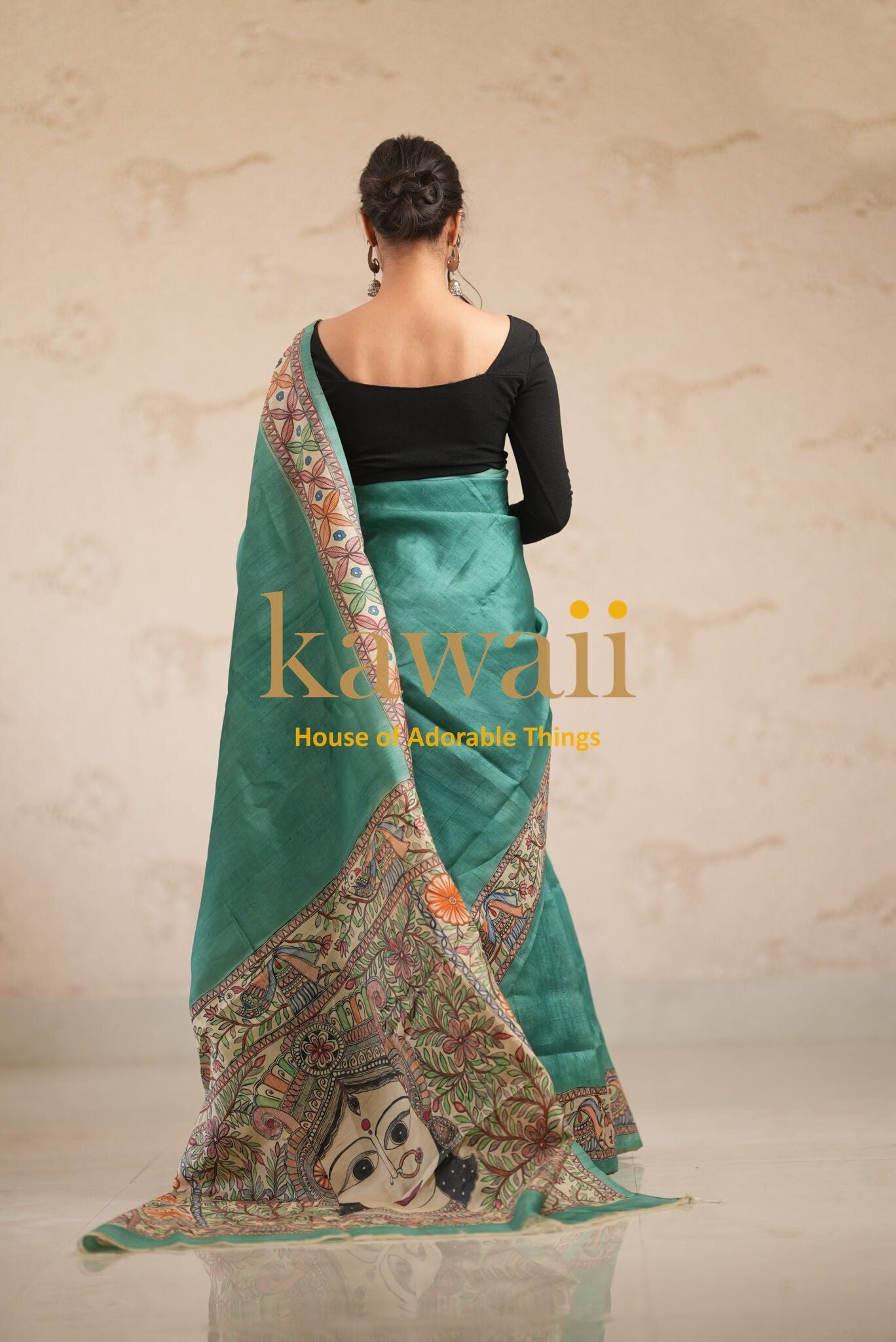Kawaii green madhubani saree with traditional artistic border worn by model facing away