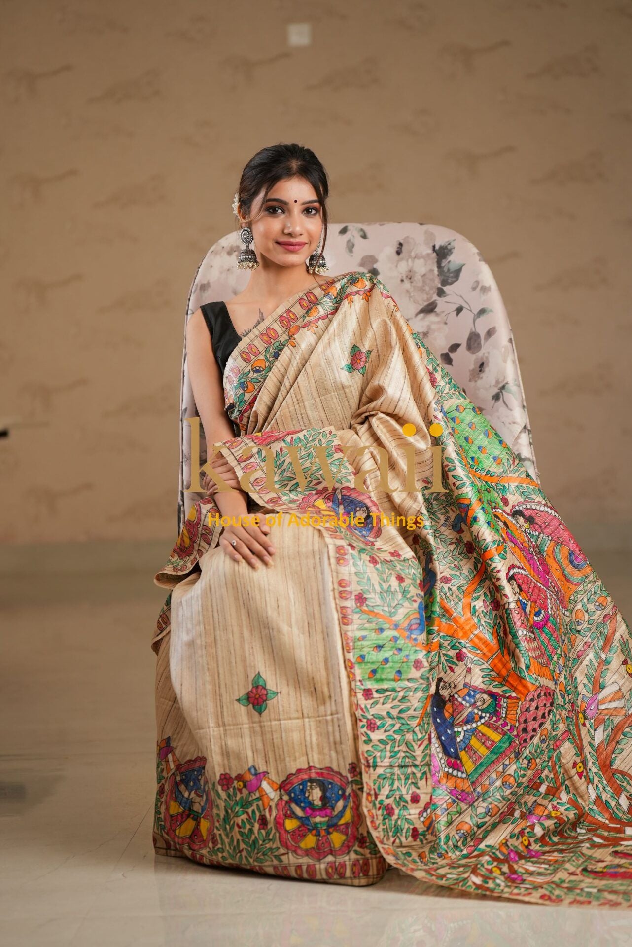 Kawaii madhubani saree with traditional colorful artwork worn by a woman sitting on a chair