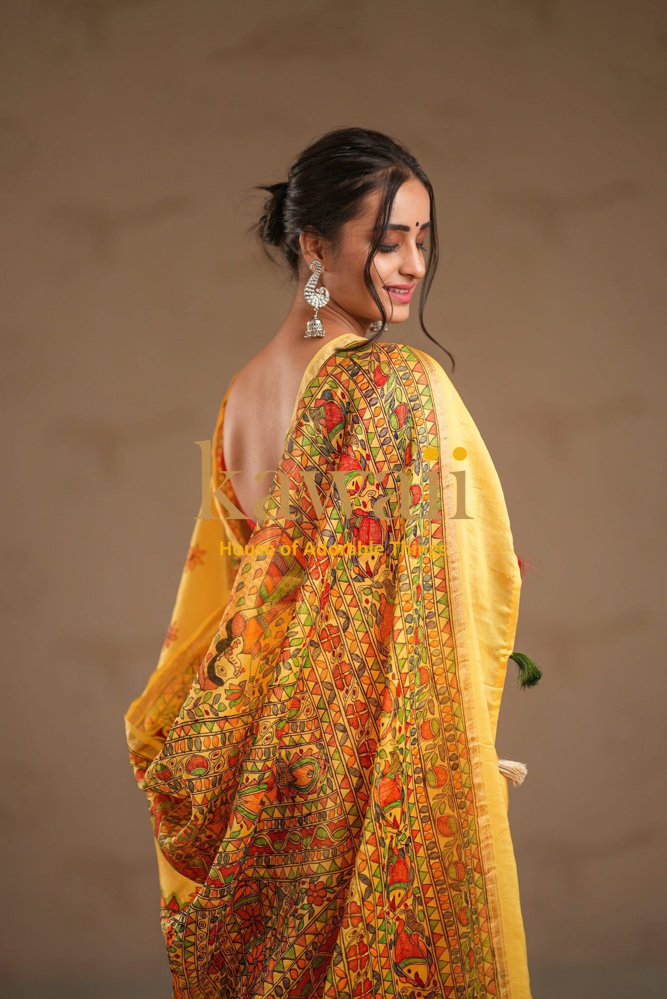 Kawaii madhubani saree with intricate yellow and orange traditional Indian art design worn by a woman