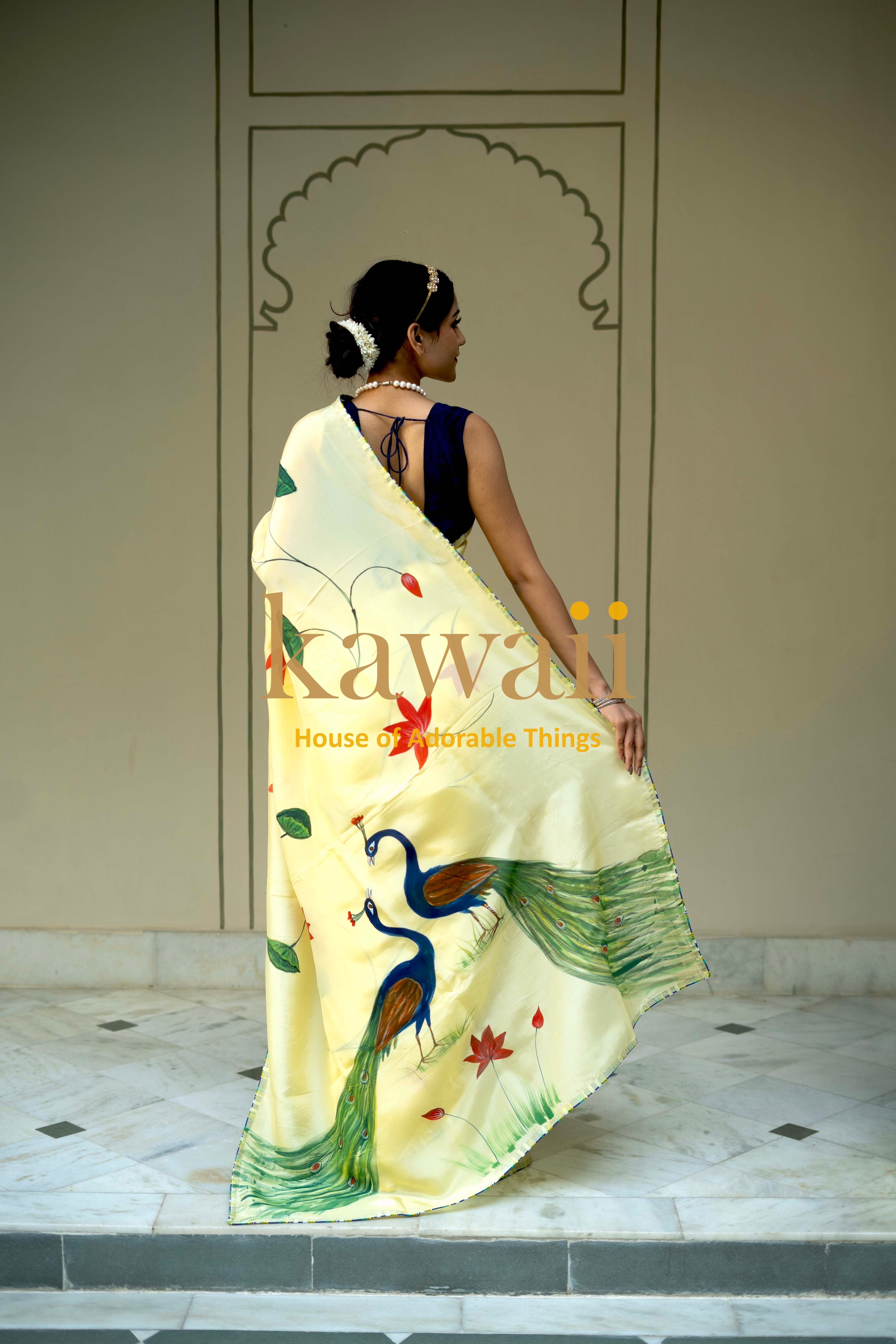 Kawaii pichwai saree with detailed peacock and floral design draped on woman in traditional setting
