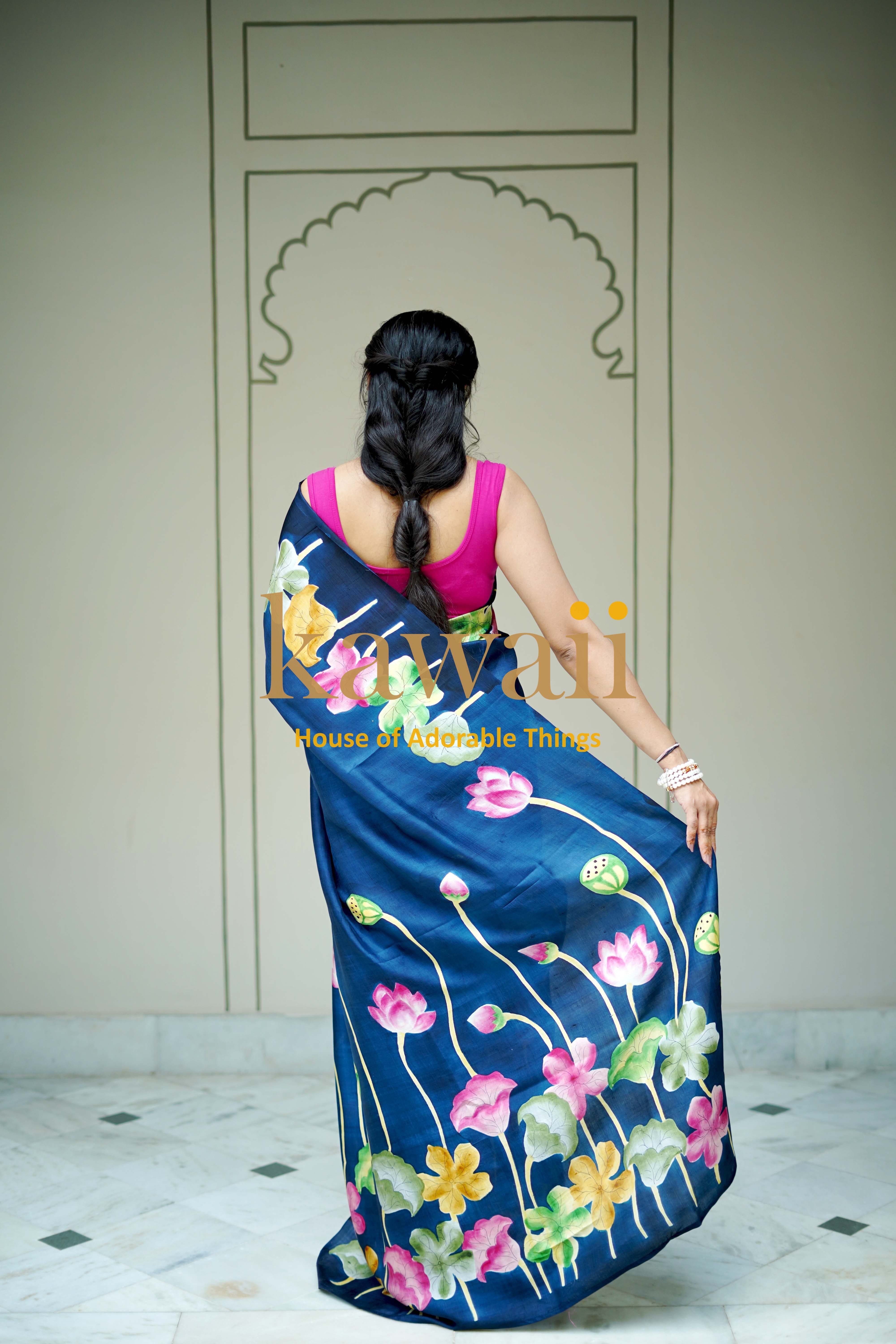 Kawaii pichwai saree in navy blue with vibrant floral designs worn by a woman seen from the back